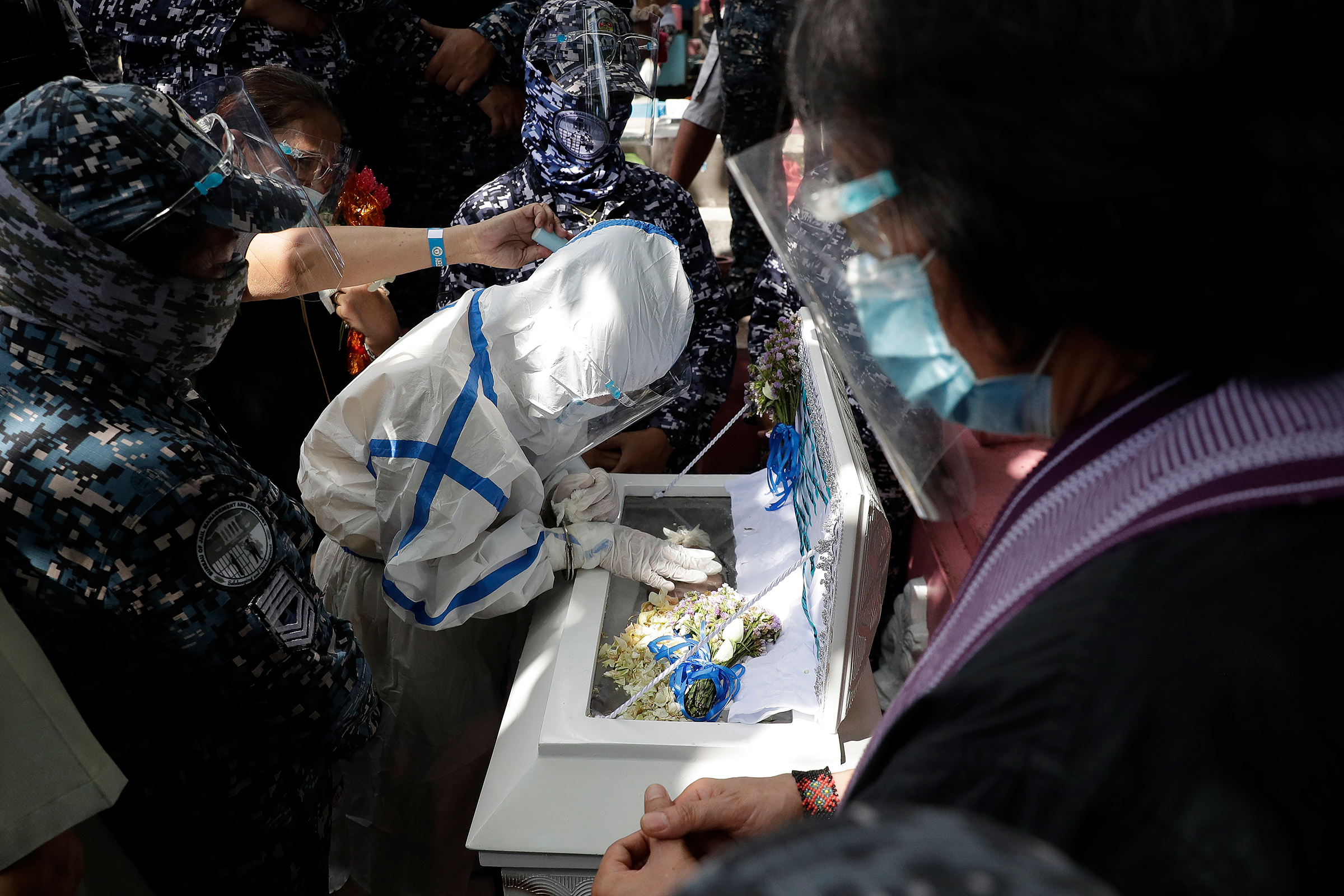 Detained left-wing activist Reina Mae Nasino, in handcuffs and wearing a protective suit to prevent the spread of coronavirus, touches the coffin of her three-month-old daughter, River, during funeral rites guarded by armed escorts at Manila North Cemetery on Oct. 16. The 23-year-old was among three activists arrested last year in a Philippine left-wing group’s office, the Associated Press reports, and charged with the illegal possession of explosives and firearms; their lawyers allege that the weapons were placed by police, which denied the accusation. A court allowed Nasino three hours to attend the burial of her baby, who died of acute gastroenteritis, the AP adds, but critics decried her treatment.