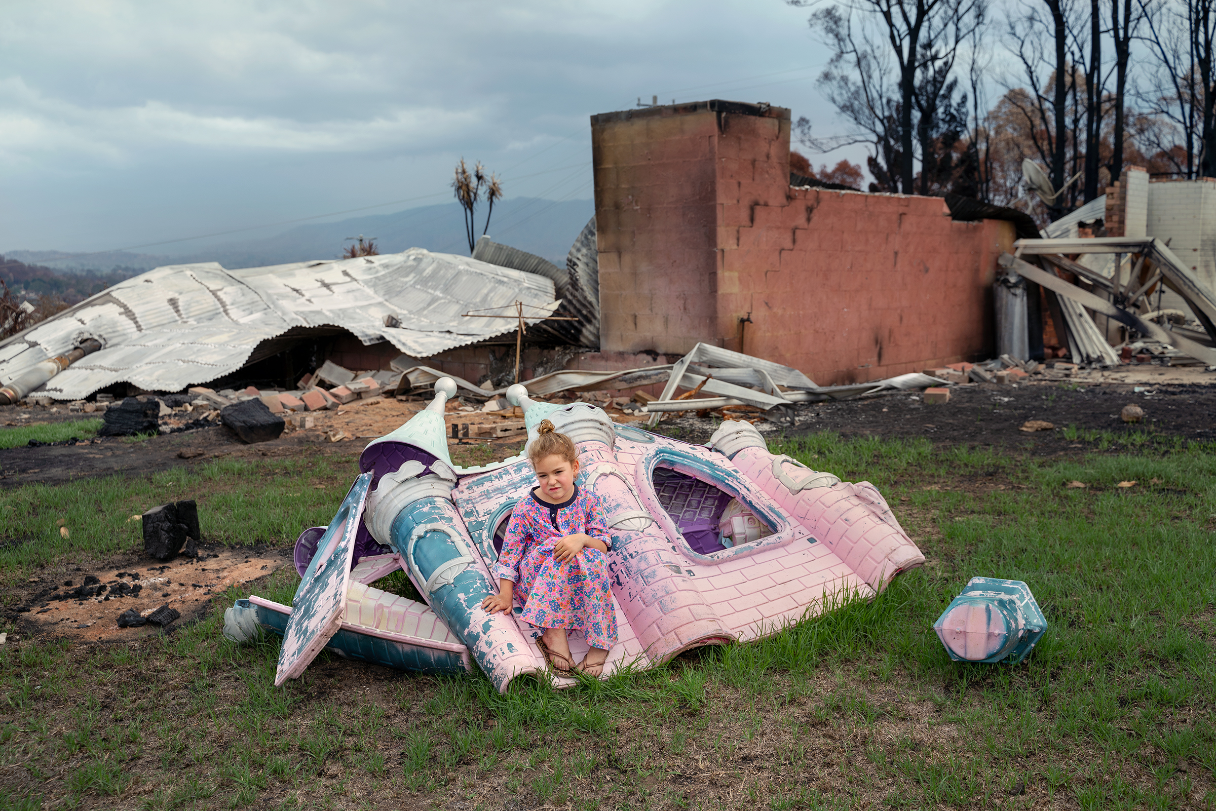Sarah Rugendyke, 7, sits on a play castle that was <a href="https://time.com/longform/australia-wildfires-bush-pictures/" target="_blank" rel="noopener noreferrer">burned on her family’s property</a> in Cobargo on Jan. 20; an out-of-control bushfire devastated the tourist town about 240 miles south of Sydney on New Year’s Eve. (Adam Ferguson for TIME)