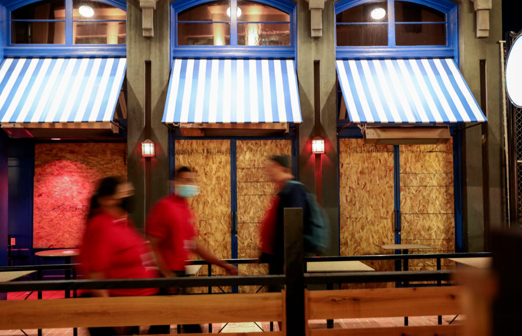 Boarded-up shops along 5th Avenue in the Gaslamp Quarter before an imposed curfew on November 21, 2020 in San Diego, California. (Photo by Sandy Huffaker/Getty Images)
