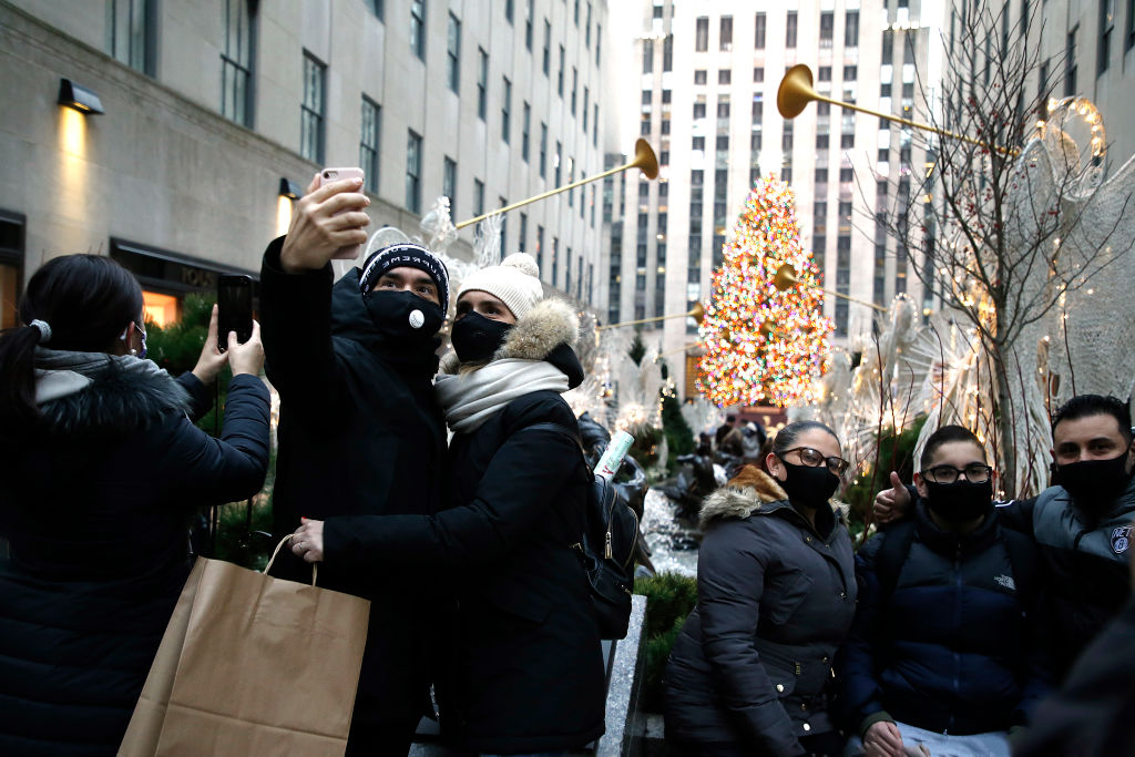 A couple wearing protective masks take a selfie with the Rockefeller Christmas Tree in the background on Dec. 6, 2020 in New York City. (Getty Images—John Lamparski)