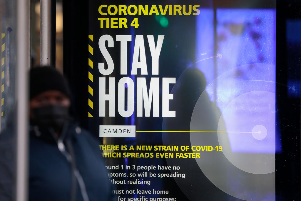 A Coronavirus Tier 4 Stay Home poster near King's Cross railway station in London, U.K., on Monday, Dec. 21, 2020. (Jason Alden/Bloomberg via Getty Images)