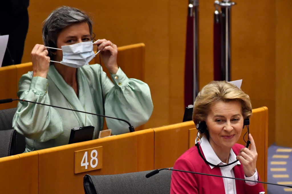 Margrethe Vestager, competition commissioner of the European Commission, left, puts on a protective face mask as she sits behind Ursula von der Leyen, European Commission president, in the European Parliament in Brussels, Belgium, on Wednesday, May 27, 2020. (Geert Vanden Wijngaert/Bloomberg via Getty Images)
