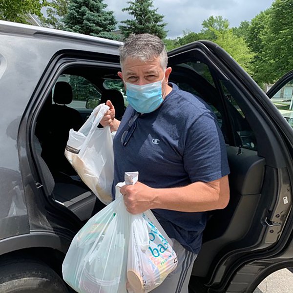 Newspaper deliveryman Greg Dailey unloading the car on May 29. Dailey began a grocery drop-off service in mid-March to anyone in need along his paper route, which has since supplied more than 140 homes in Mercer County, N.J.