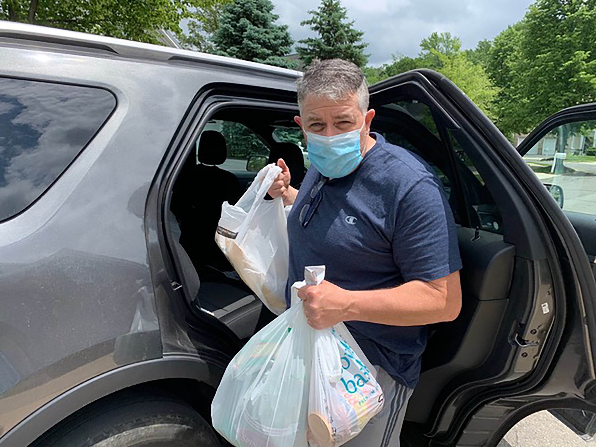 Newspaper deliveryman Greg Dailey unloading the car on May 29. Dailey began a grocery drop-off service in mid-March to anyone in need along his paper route, which has since supplied more than 140 homes in Mercer County, N.J. (Courtesy Greg Dailey)