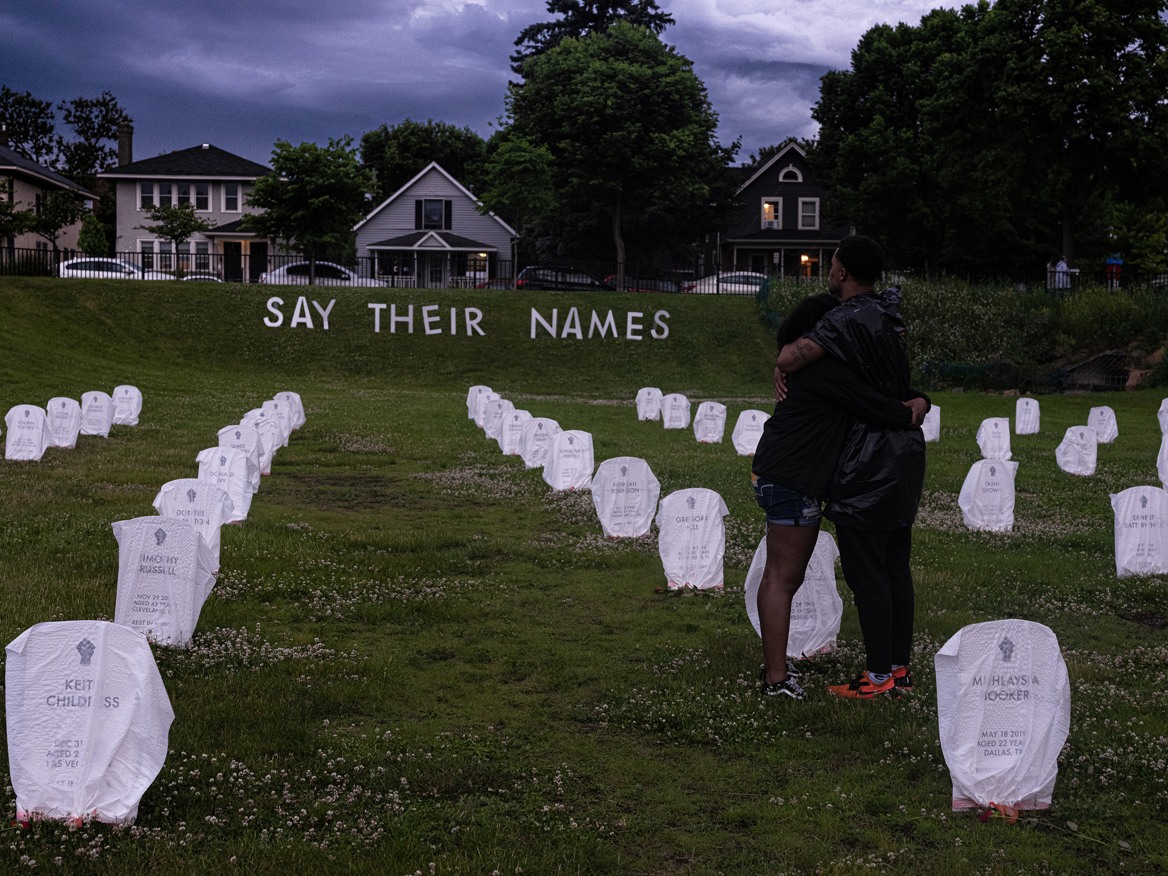 In Minneapolis on June 5, 2020, mourners embrace in front of mock headstones at a makeshift memorial to people killed by the police.