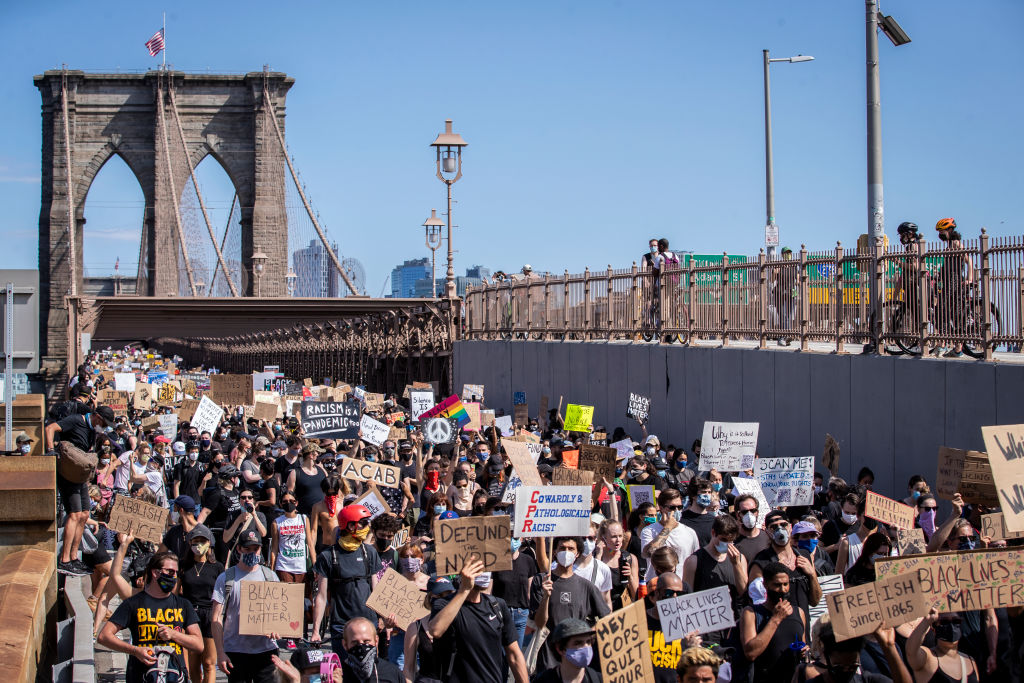 Thousands of protesters walk across the Brooklyn Bridge on 