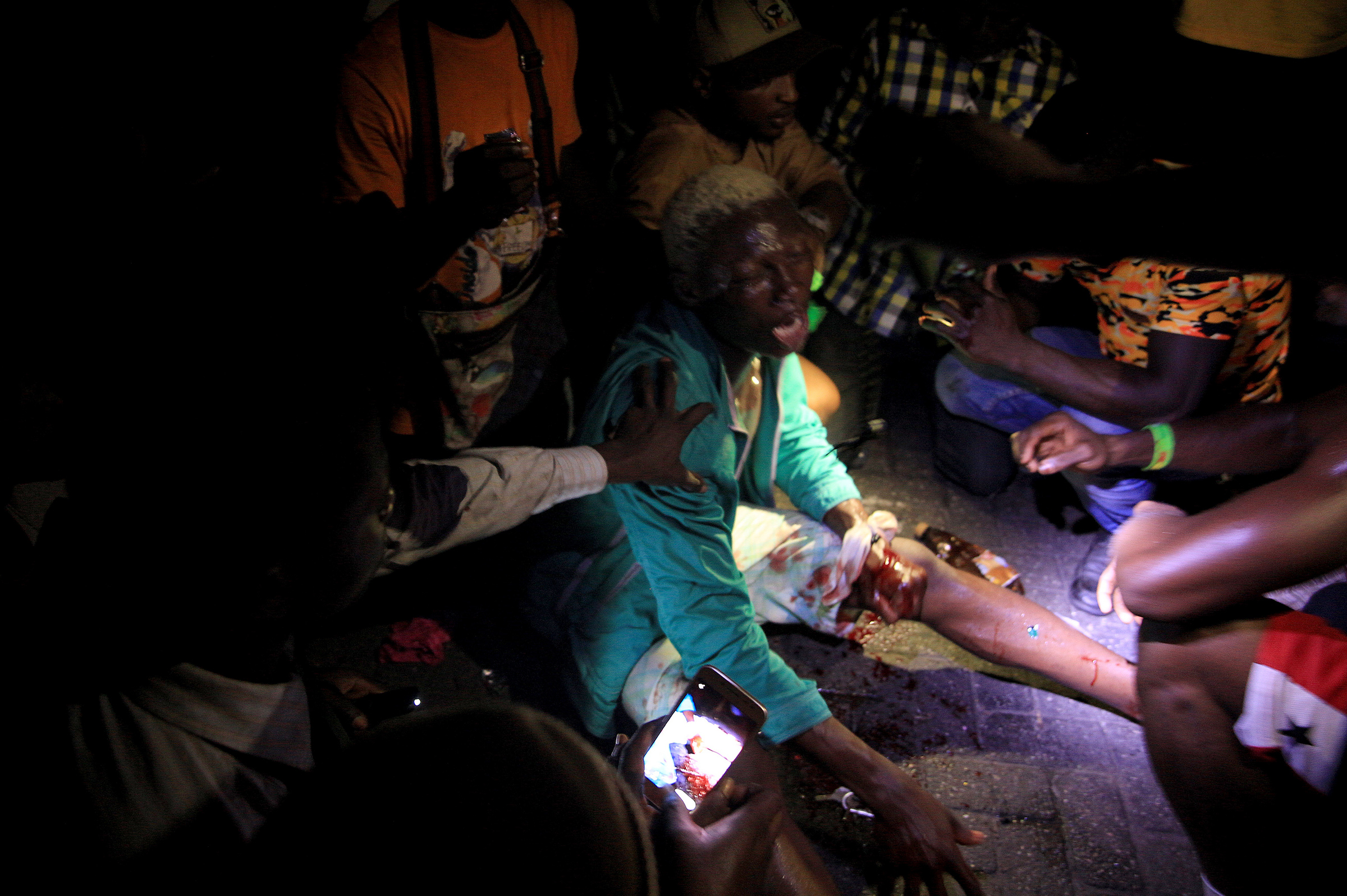 People come to the aid of a man who was wounded when security forces officers opened fire on a protest against brutality at the Lekki toll gate on Oct. 20, 2020. (Adetona Omokanye—Getty Images)