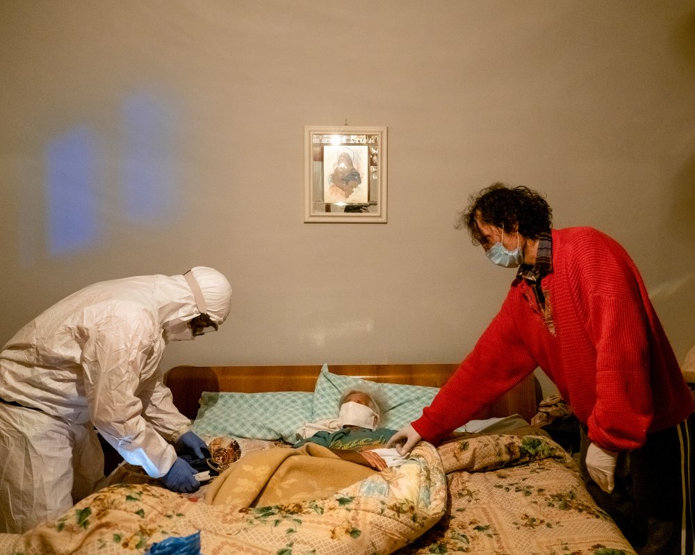 A health worker checks an elderly woman’s oxygen level after receiving a call about a suspected COVID-19 case in the northern Italian province of Bergamo.