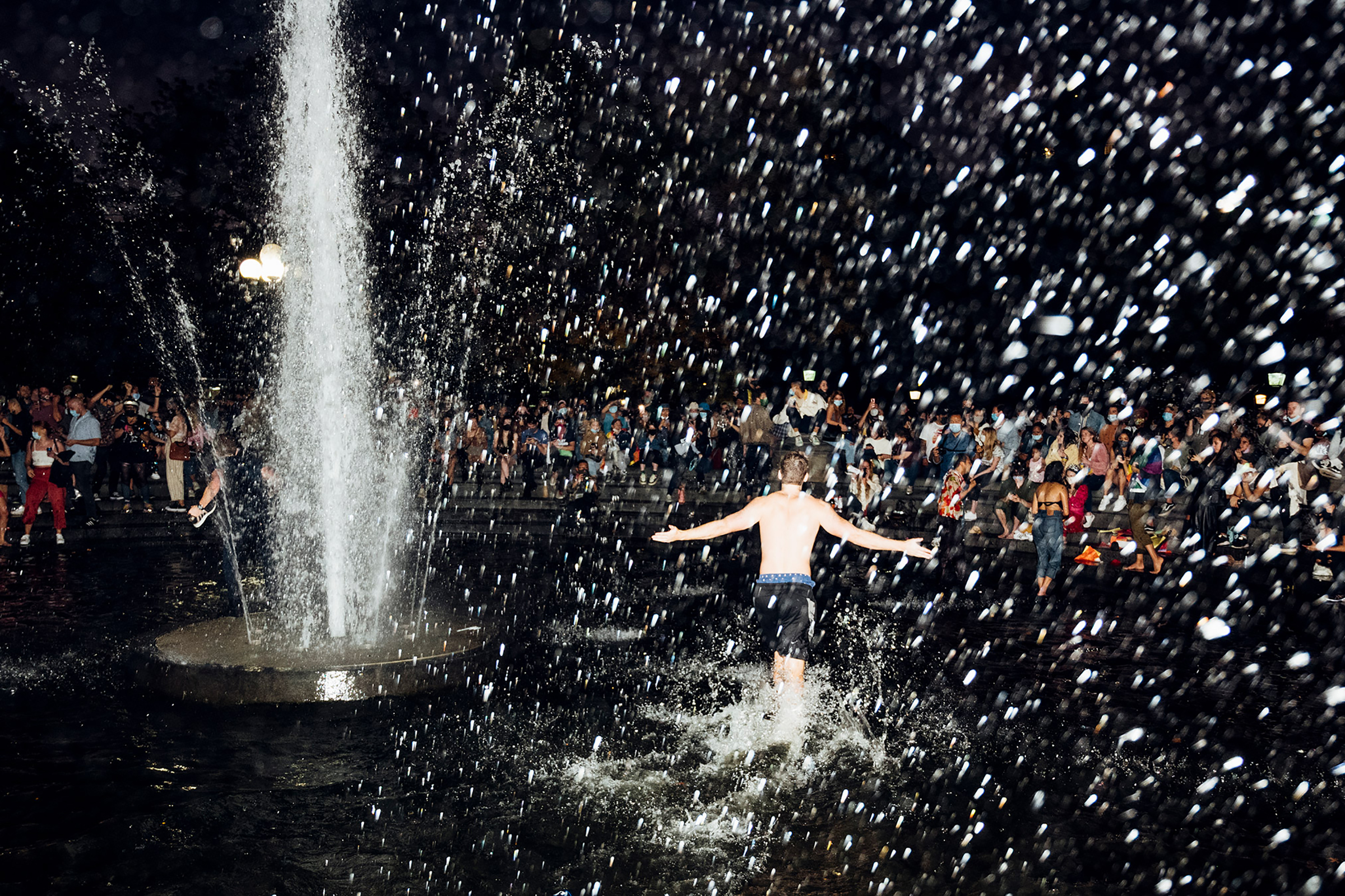 A man runs through the fountain in Washington Square Park in New York City on Nov. 7, after Joe Biden was declared the winner of the 2020 U.S. presidential election. (Malike Sidibe for TIME)