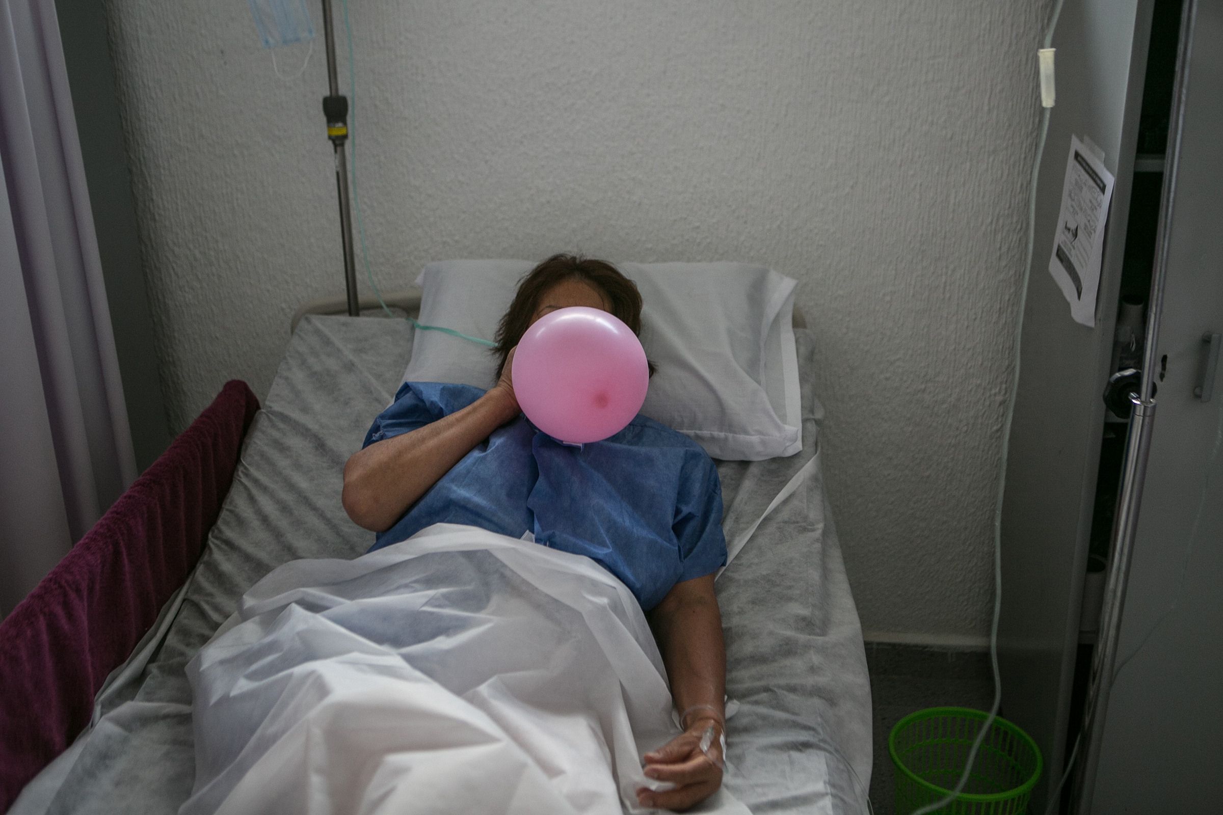 A coronavirus patient uses a balloon to strengthen her lungs as she recovers at a makeshift hospital in Mexico City on June 30, 2020.