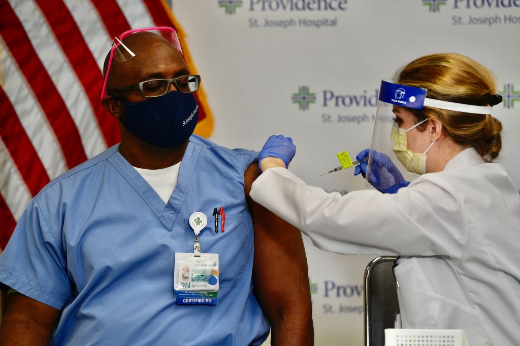 Nurse Michael Lowman gets his first dose of the Pfizer-BioNTech COVID-19 vaccine from nurse practitioner Christie Aiello at Providence St. Joseph Hospital in Orange, CA, on Dec. 16, 2020. (Jeff Gritchen—MediaNews Group/Orange County Register/Getty Images)