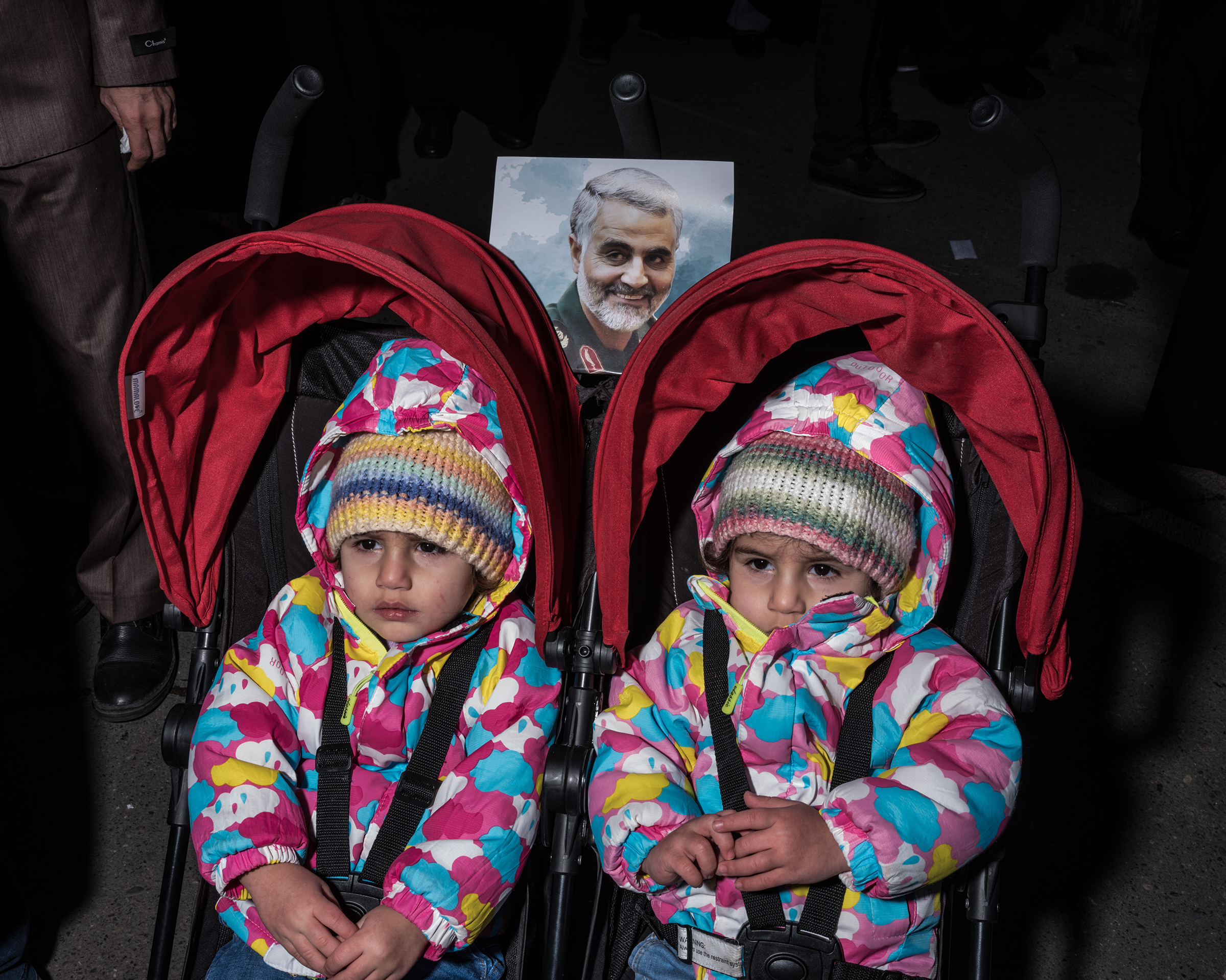 Two girls are <a href="https://time.com/longform/qasem-soleimani-tehran-iran-photos/" target="_blank" rel="noopener noreferrer">pushed in a double stroller</a> in a crowd of people in Tehran mourning the death of Qasem Soleimani. (Newsha Tavakolian—Magnum Photos for TIME)