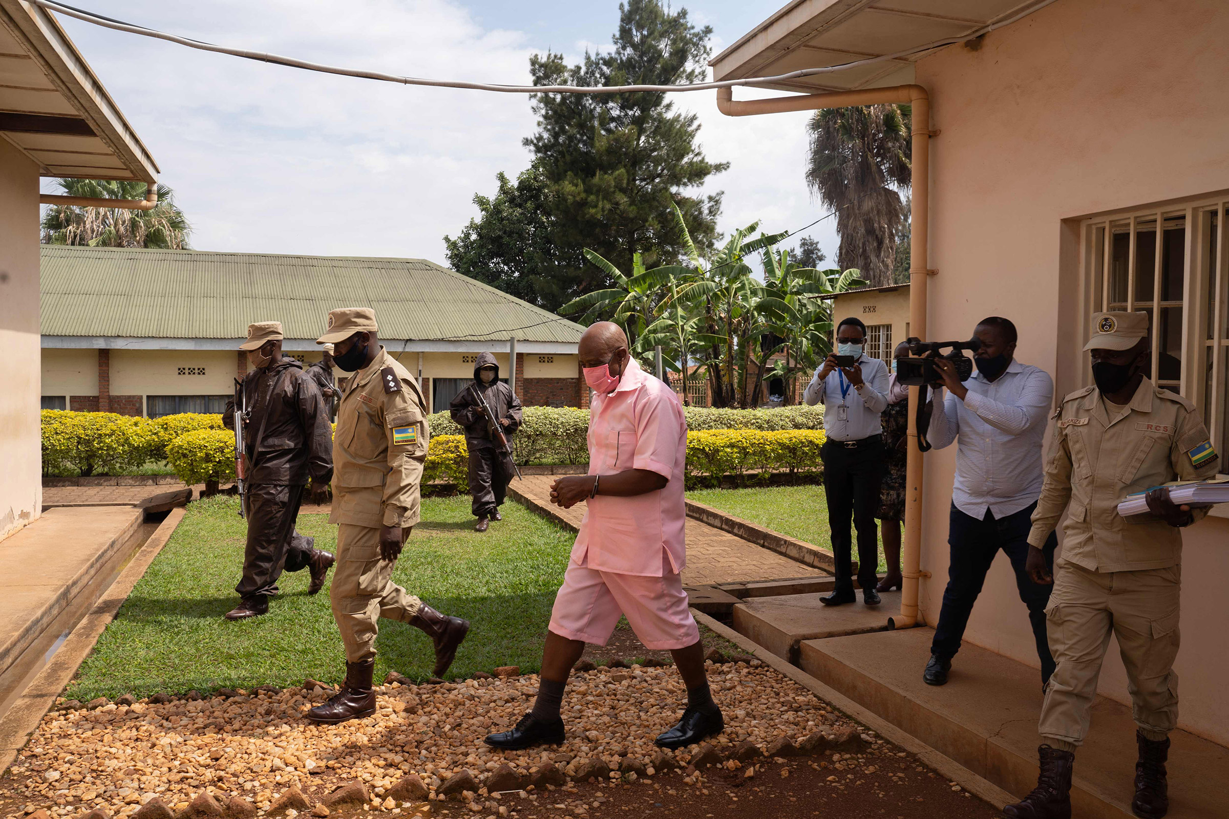 Paul Rusesabagina, center, surrounded by guards of Rwanda Correctional Service, arrives at Nyarugenge Court of Justice in Kigali, Rwanda, on Oct. 2, 2020. (Simon Wohlfahrt—AFP/Getty Images)