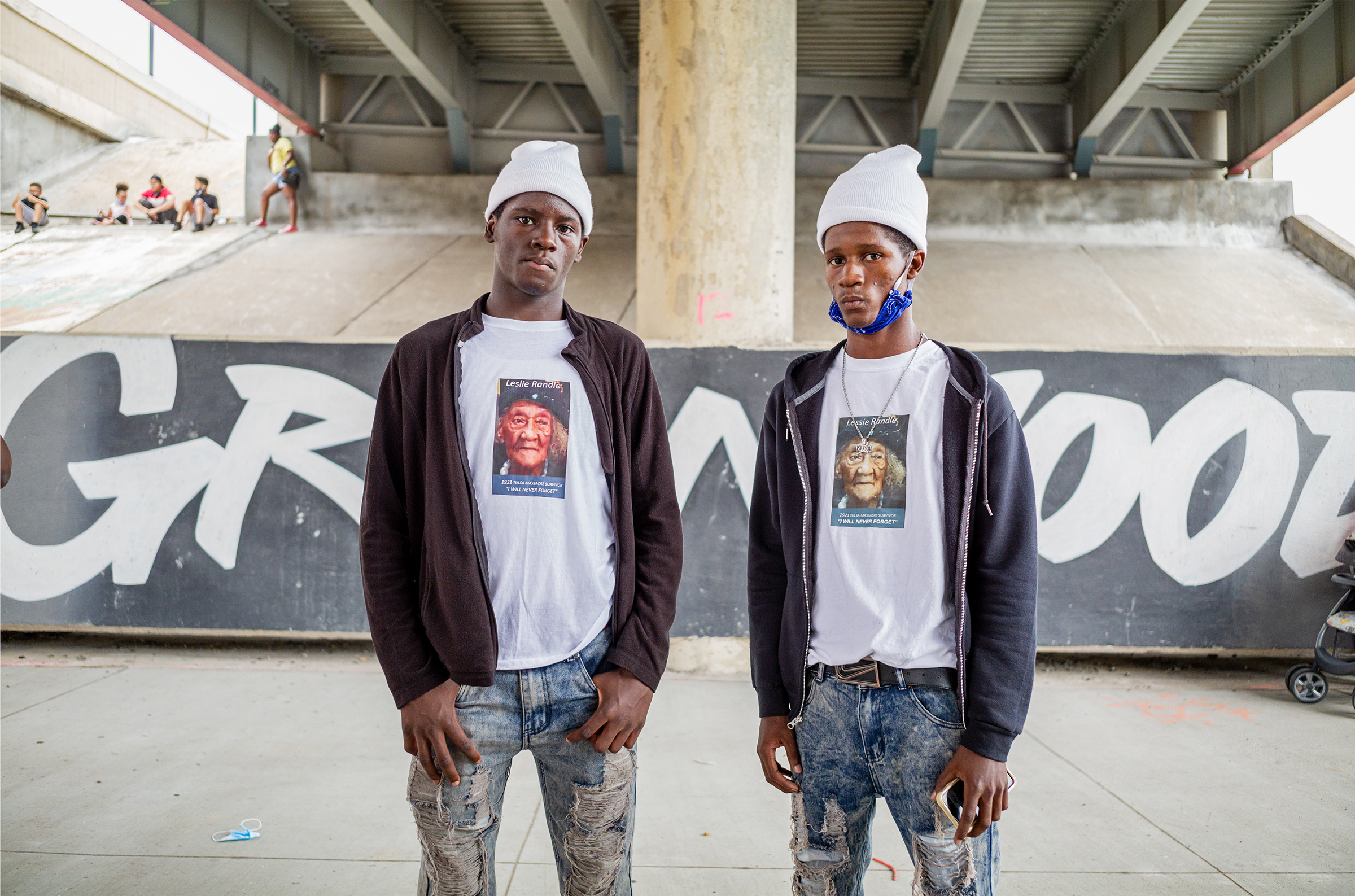 At Juneteenth celebrations in Tulsa's Greenwood district, the site of one of American history’s worst-ever episodes of racial violence, Deshon and Omarion wear T-shirts depicting their grandmother Leslie Randle—who was alive during the 1921 massacre, when hundreds of Black-owned homes and businesses in the area were burned and more than 300 Black people were killed. 