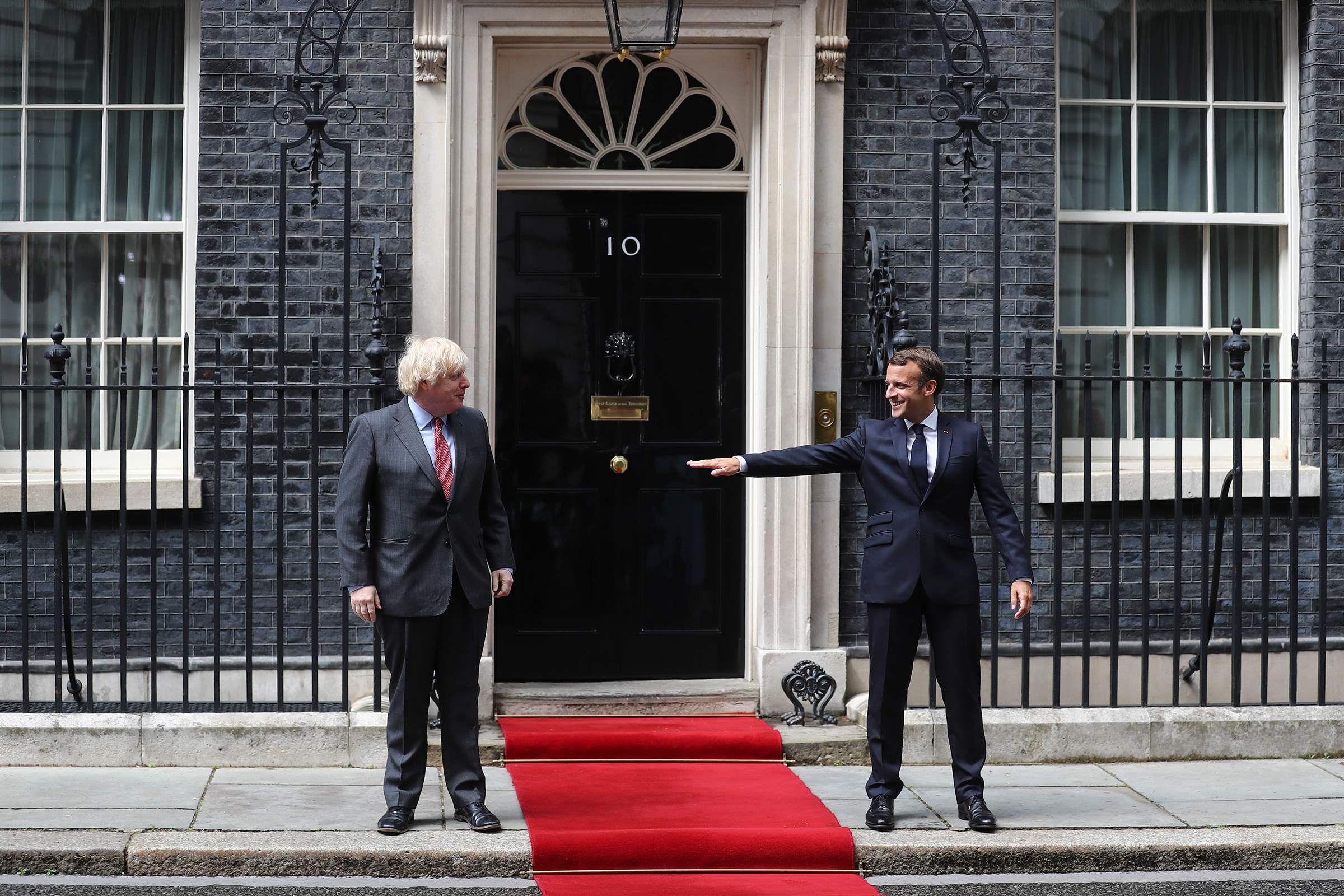 Boris Johnson, prime minister of the United Kingdom, and French President Emmanuel Macron stand socially distanced while posing for photographs at 10 Downing Street in London on June 18, 2020.