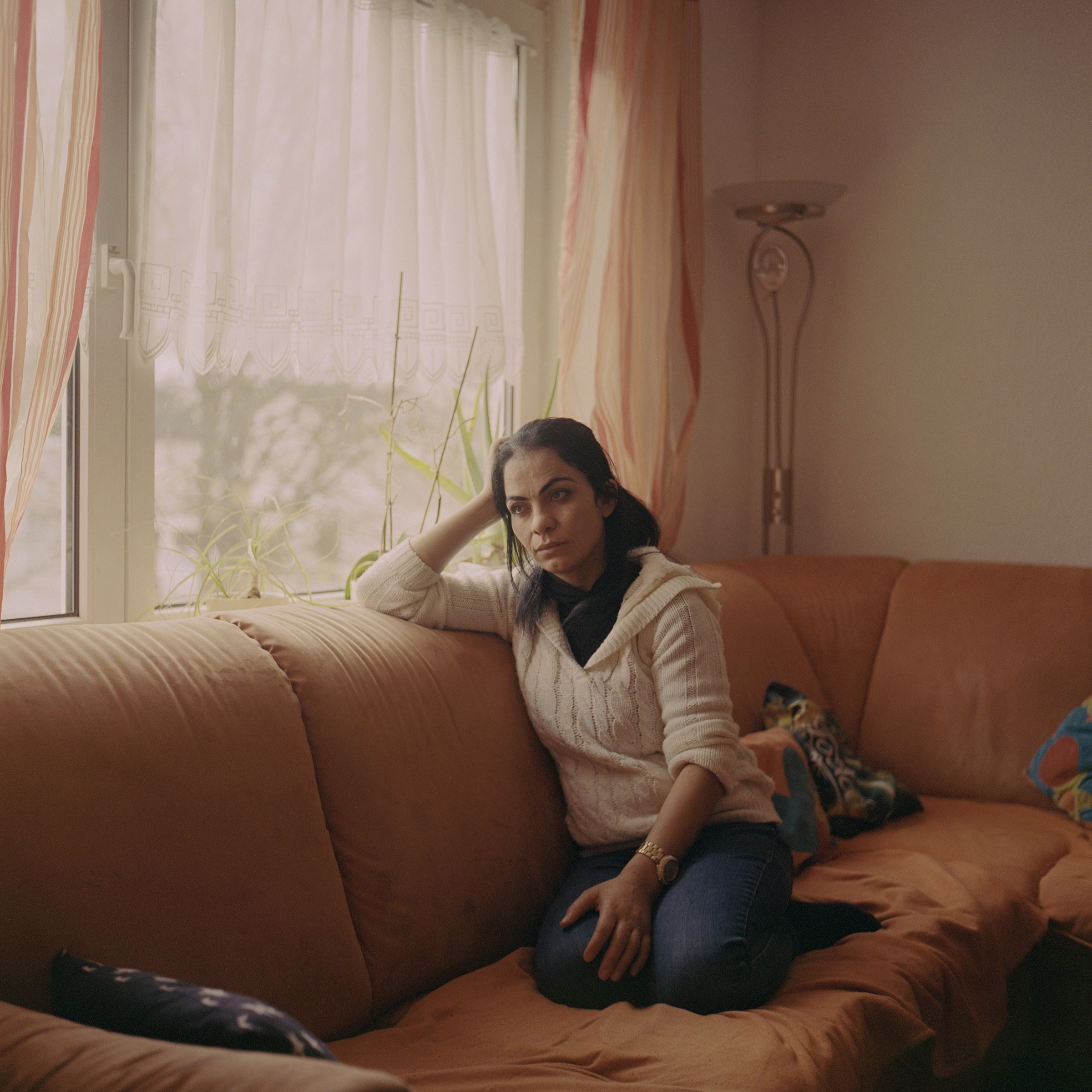 <strong>Hanan</strong> on the sofa in her living room in Germany. "<a href="https://time.com/5878967/yazidi-woman-germany-program/">A Radical German Program Promised a Fresh Start to Yazidi Survivors of ISIS Captivity. But Some Women Are Still Longing for Help</a>," Aug. 24. (Tori Ferenc—INSTITUTE for TIME)