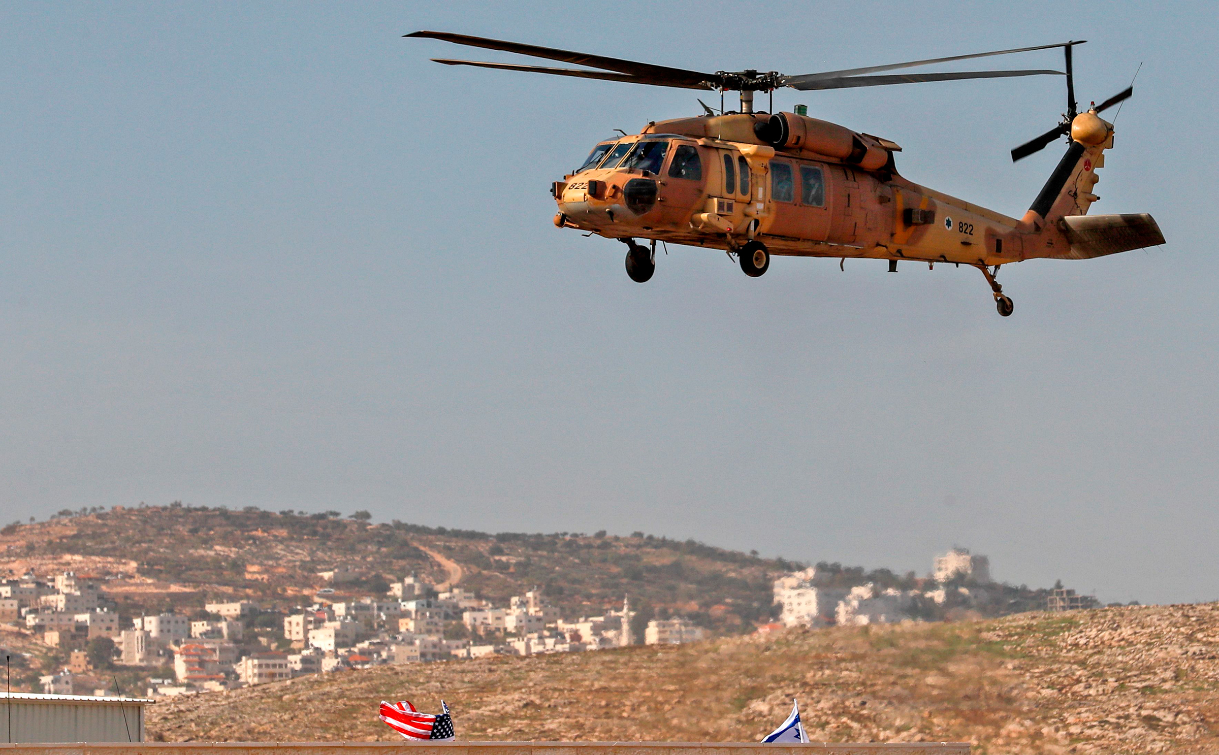 An Israeli airforce helicopter carrying US Secretary of State Mike Pompeo hovers over the settlers industrial park of Sha'ar Binyamin, with the Palestinian village of Burqa in the background, in the occupied West Bank on Nov. 19 (Ahmad Gharabli—AFP/Getty Images)