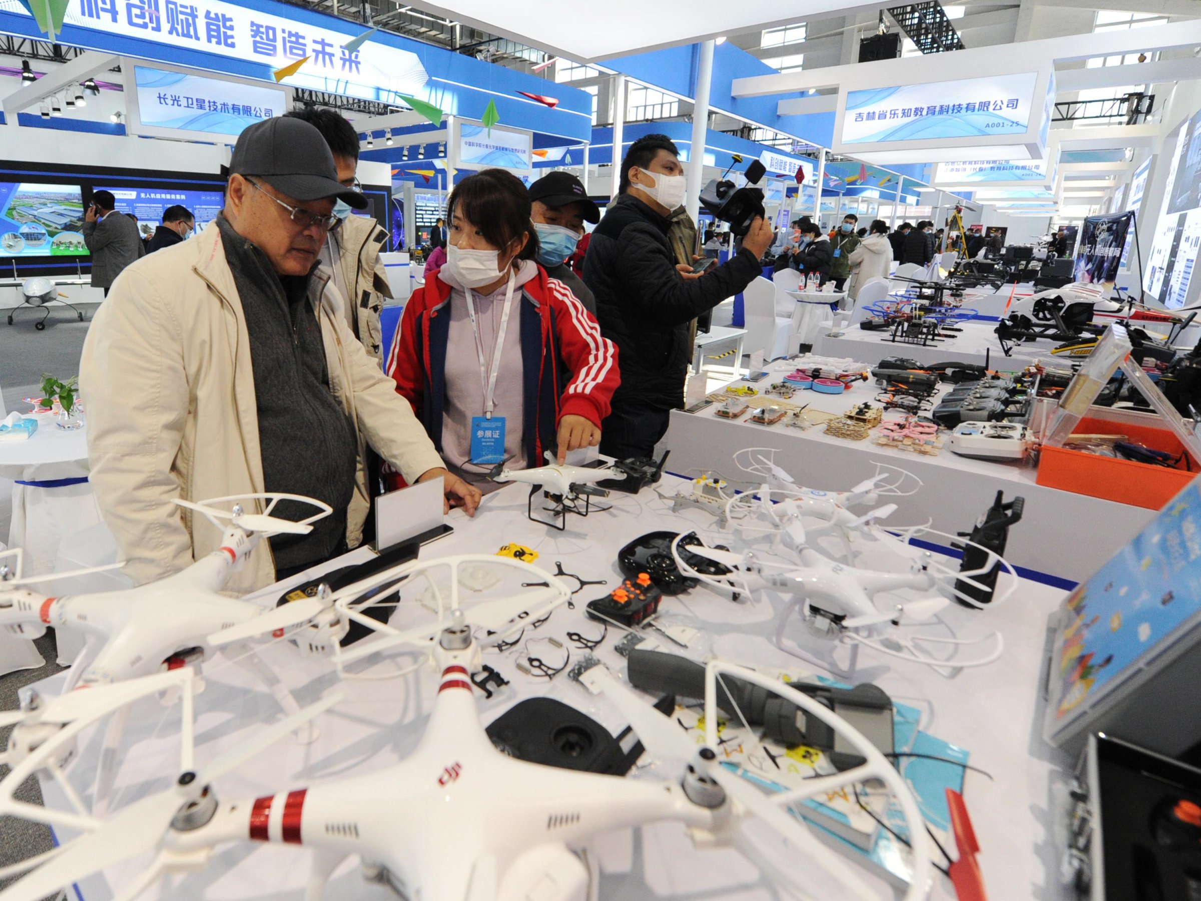 People look at drones at the DJI stand during the 2020 Changchun International UAV Industry Expo at CCIAFF Expo park on October 16, 2020 in Changchun, Jilin Province of China.