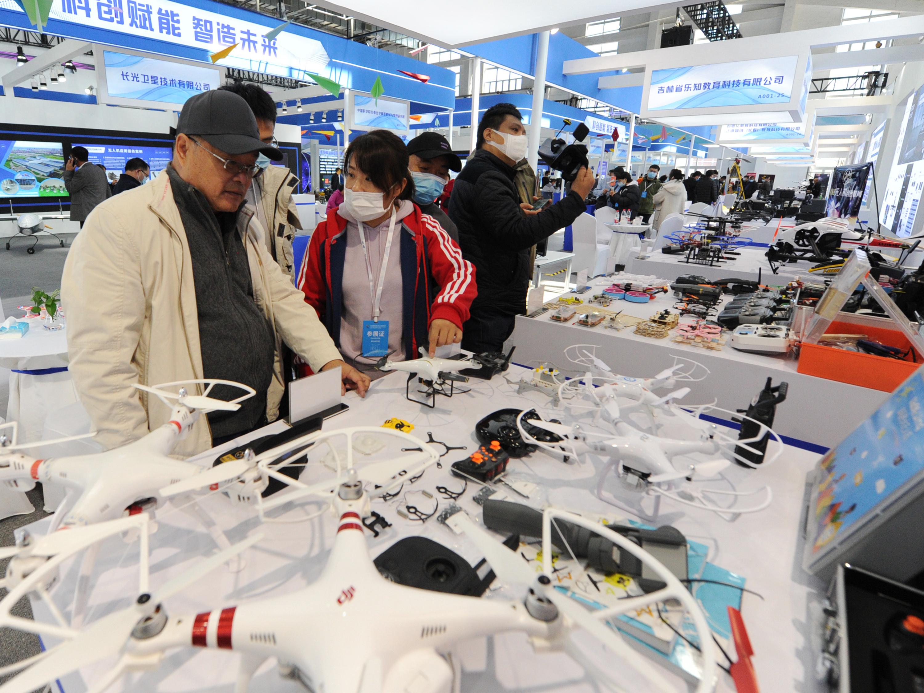 People look at drones at the DJI stand during the 2020 Changchun International UAV Industry Expo at CCIAFF Expo park on October 16, 2020 in Changchun, Jilin Province of China. (Liu Dong—China News Service/Getty)