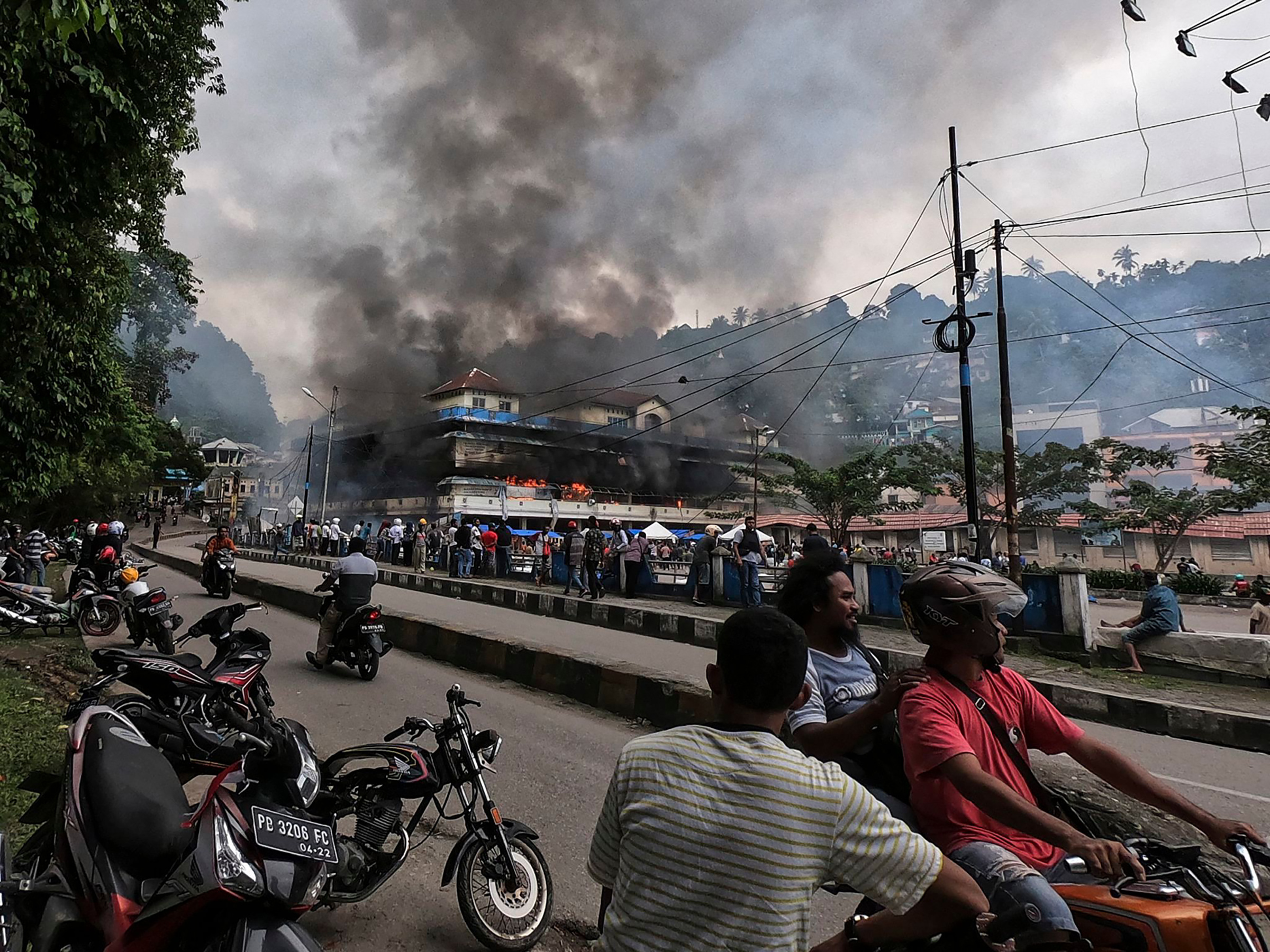 Papuans gather outside the burning Buruni market in Fakfak, West Papua, after it was torched by protesters on Aug. 2019 as unrest triggered by accusations that security insulted Papuan students in Surabaya continued (Beawiharta—EPA-EFE/Shutterstock)