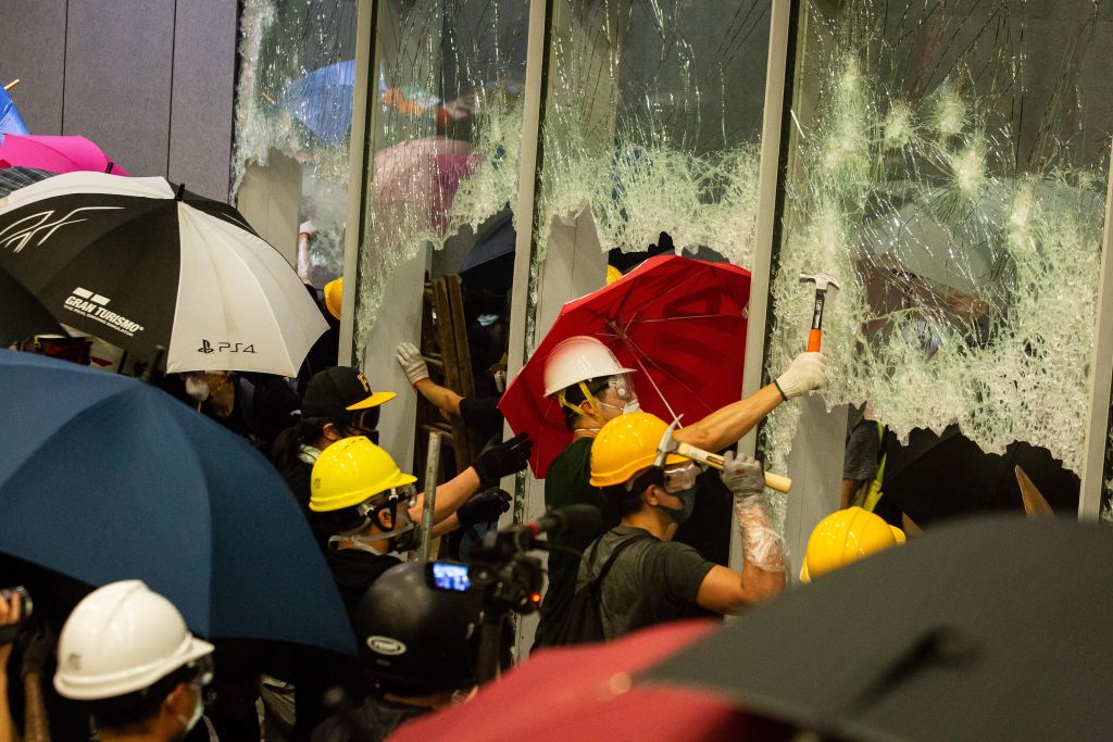 Demonstrators use hammers to break windows at the Legislative Council building during a protest in Hong Kong, China, on July 1, 2019. (Eduardo Leal—Bloomberg/Getty Images)