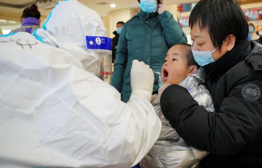 A medical worker collects a swab sample from a child a community COVID-19 testing site in Qiaoxi District of Shijiazhuang, capital of north China's Hebei Province, Jan. 12, 2021. (Xinhua/Mu Yu via Getty Images)