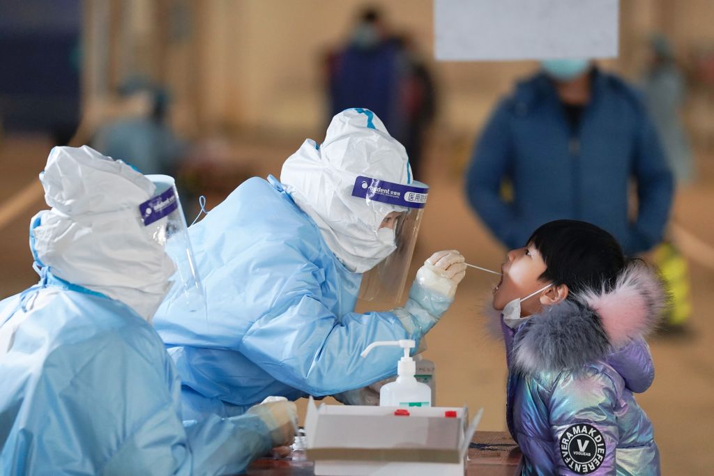 A medical worker collects a swab sample from a child at a COVID-19 testing site in Daxing District of Beijing, capital of China, Jan. 20, 2021. (Xinhua/Ju Huanzong via Getty Images)