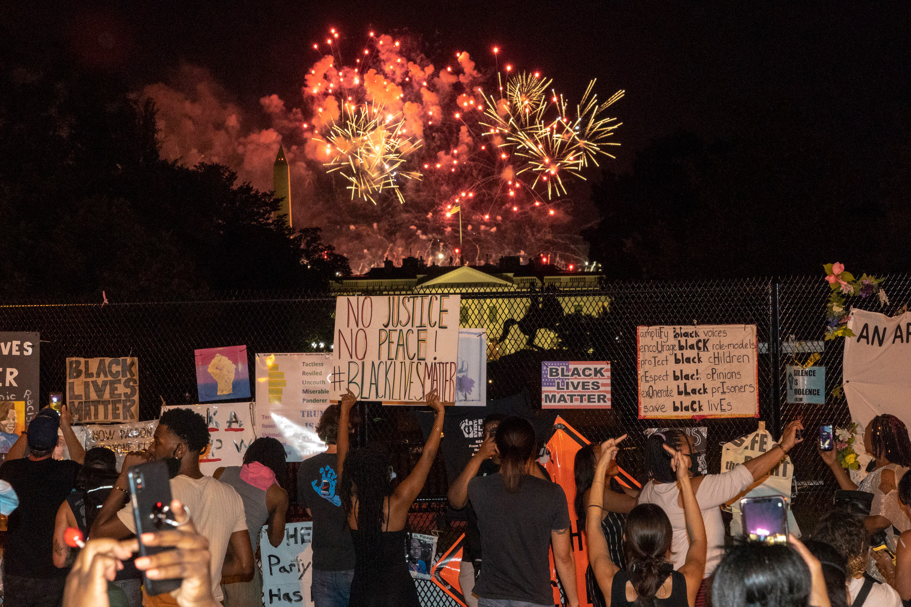 <strong>Washington, Aug., 27, 2020.</strong> "A modest number of protesters gathered outside the fence sealing off the White House from Black Lives Matter Plaza. As Trump's speech accepting the Presidential nomination ended, a massive display of fireworks filled the air. Some protesters pressed against the fence to shout obscenities and wave their middle finger towards the White House. It feels as if the tension is only going to ramp up as the election quickly approaches." (Peter van Agtmael—Magnum Photos for TIME)