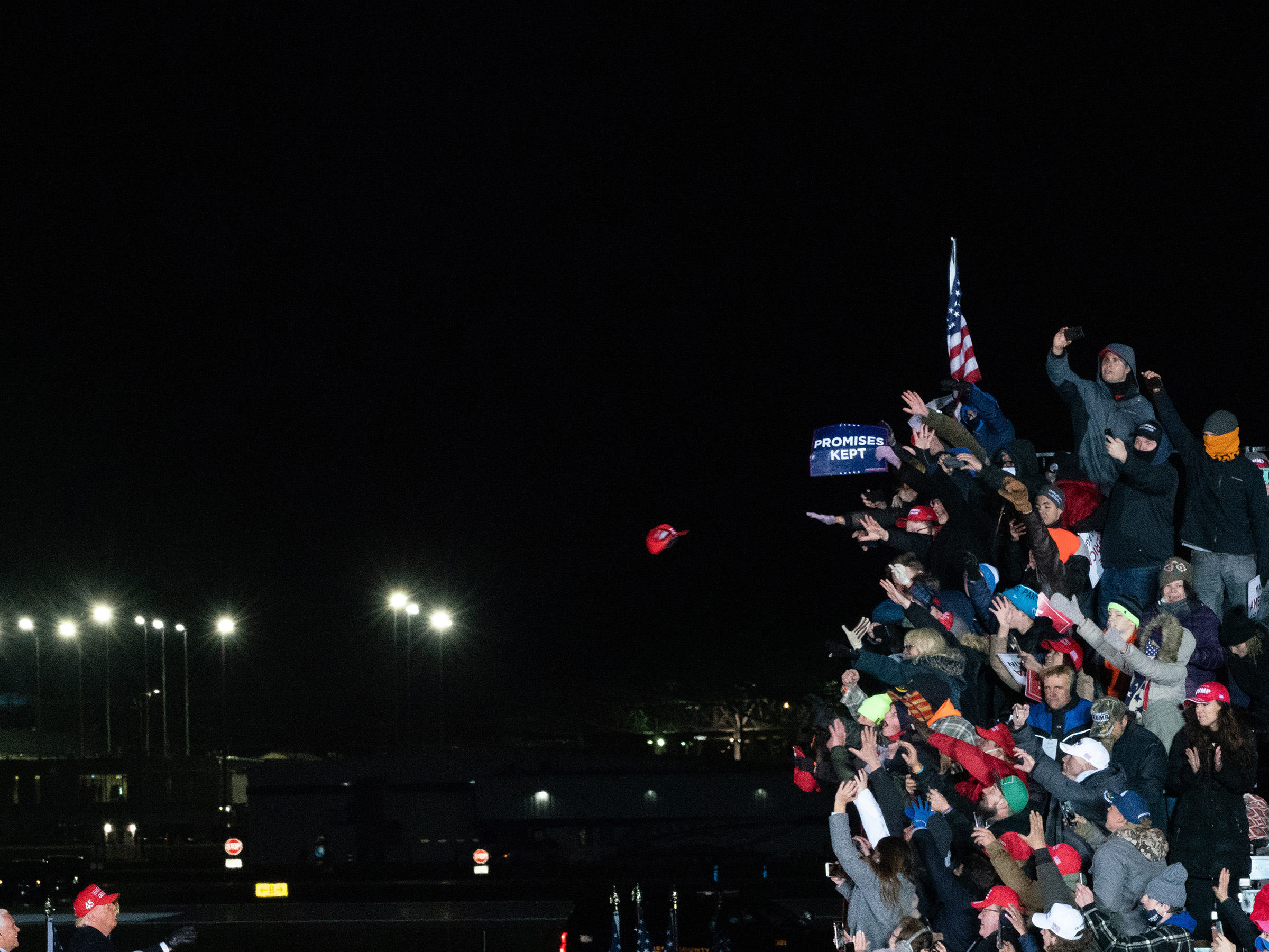 <strong>Grand Rapids, Mich., Nov. 3, 2020.</strong> A hat is tossed between Trump and his supporters at the President's final rally before the election. (Peter van Agtmael—Magnum Photos for TIME)