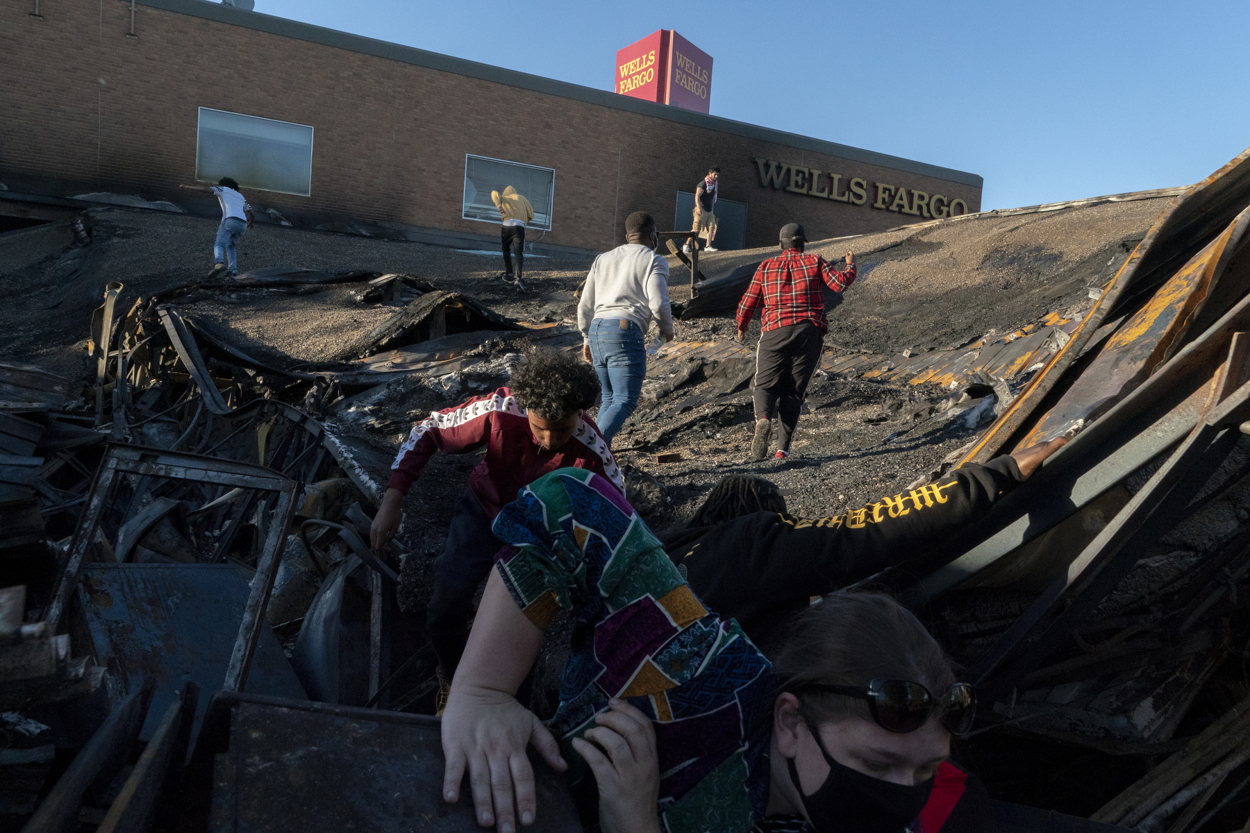 <strong>Minneapolis, May 30, 2020.</strong> People visit and take selfies on the collapsed roof of a Wells Fargo, destroyed in the riots and arson that followed the killing of George Floyd. (Peter van Agtmael—Magnum Photos)