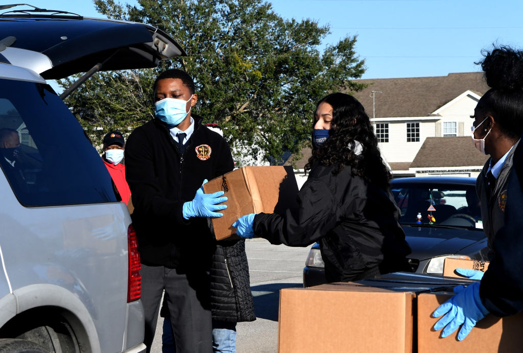Volunteers load boxes of food assistance into cars at the Share Your Christmas food distribution event sponsored by the Second Harvest Food Bank of Central Florida, Faith Neighborhood Center, and WESH 2 at Hope International Church on December 9, 2020 in Groveland, Florida, near Orlando. Central Florida food banks struggle to serve those facing food insecurity during the holiday season amid the COVID-19 pandemic. (Photo by Paul Hennessy/NurPhoto via Getty Images)