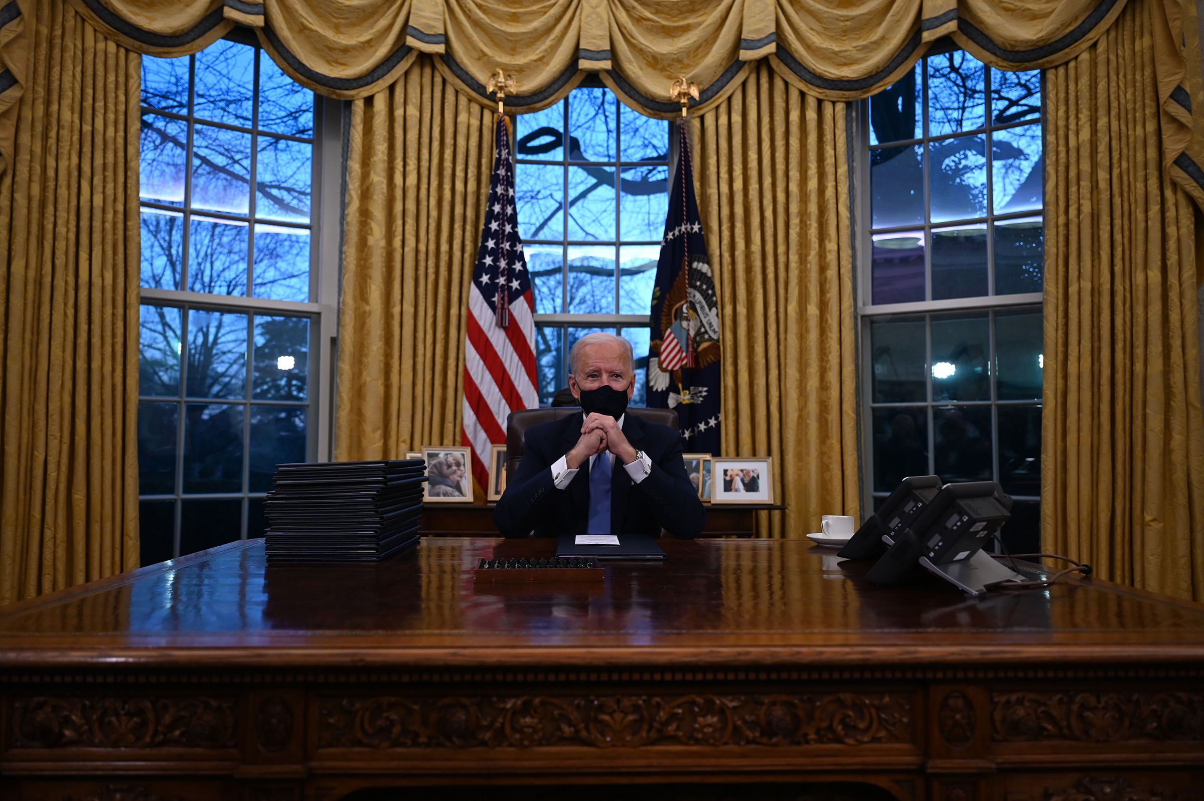 President Joe Biden sits in the Oval Office at the White House, after being sworn in.