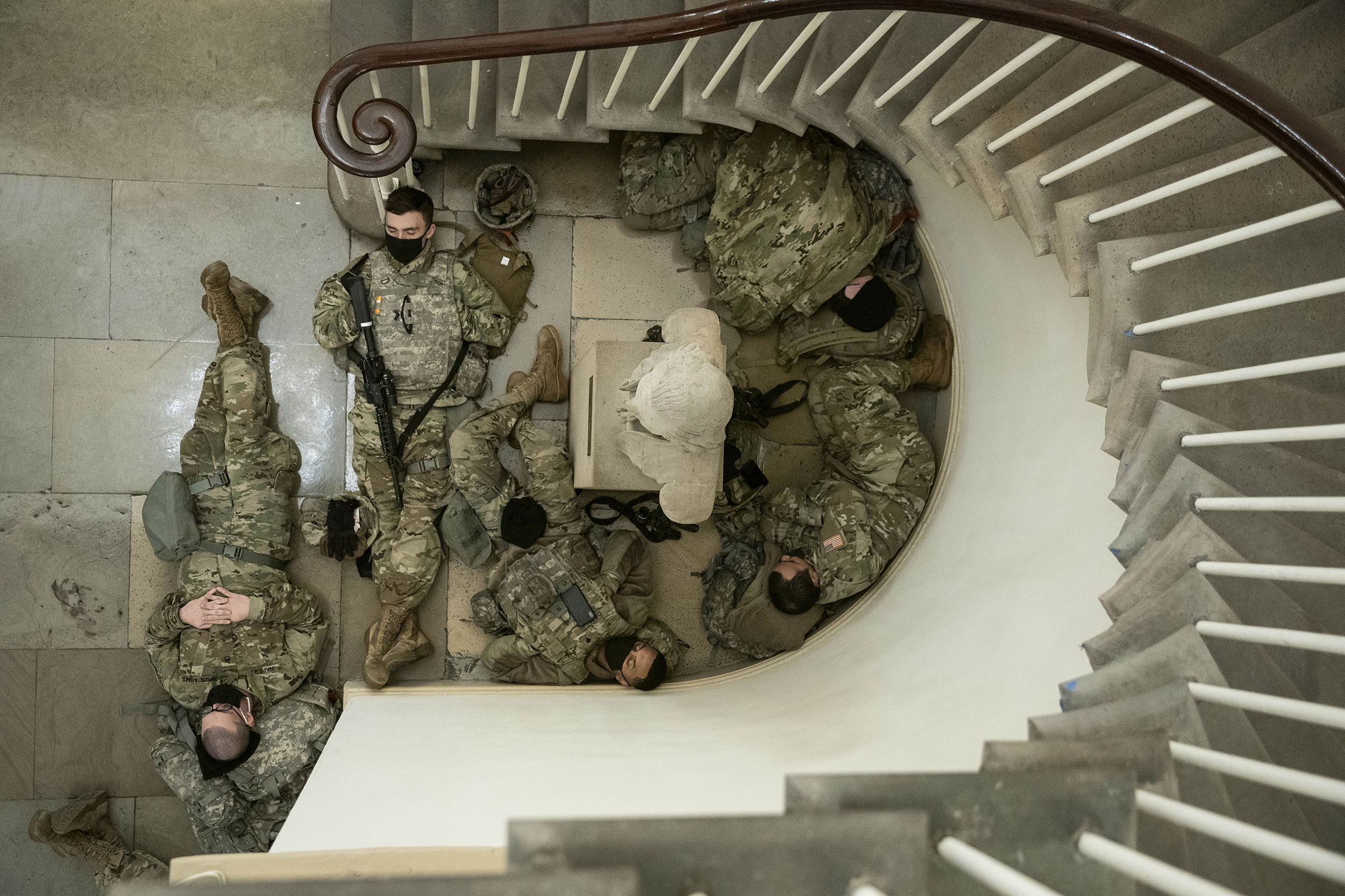 Members of the National Guard rest in a hallway of the Capitol building in Washington, on Jan. 13, 2021. (Sarah Silbiger—Bloomberg/Getty Images)
