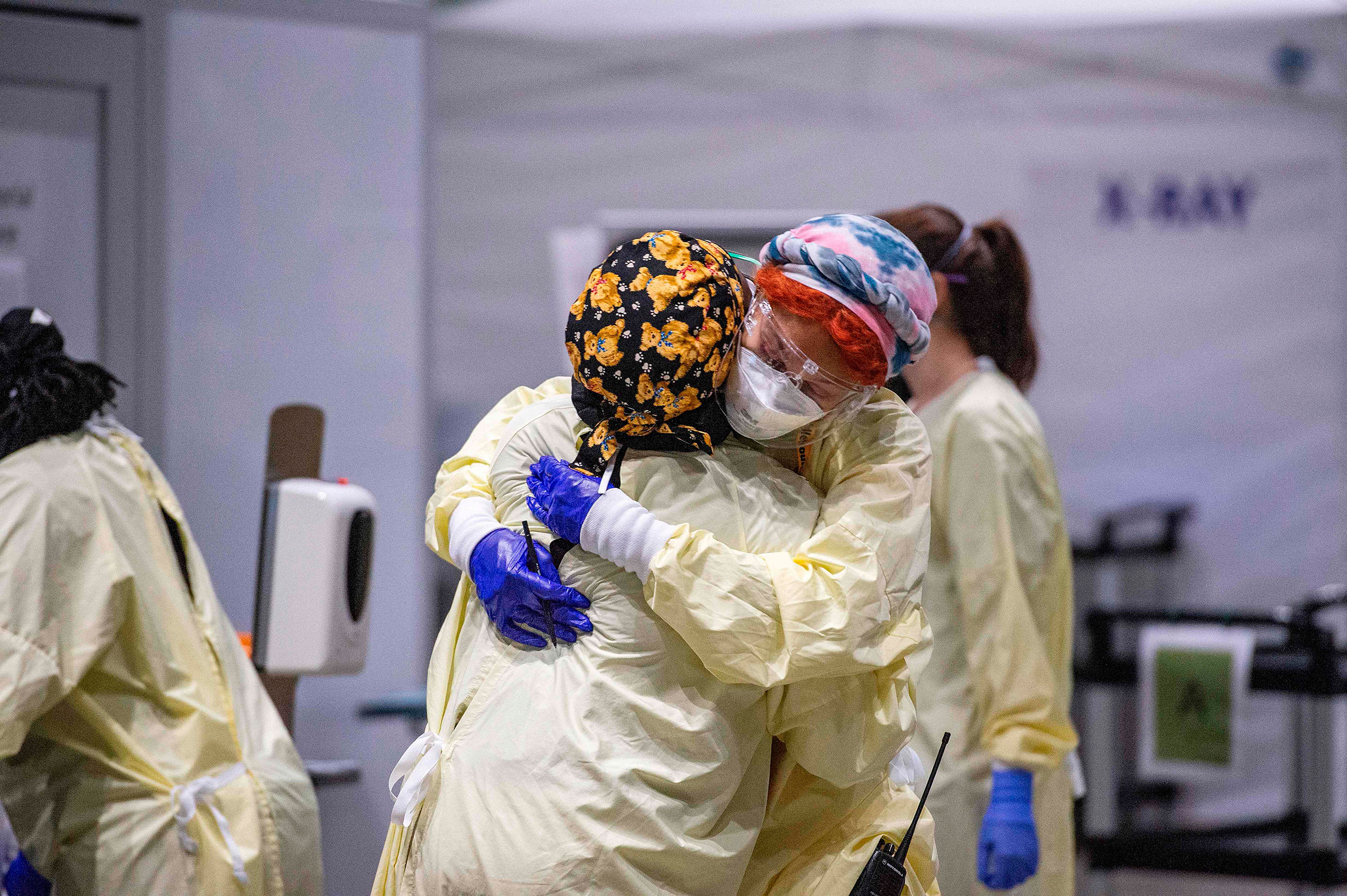 Medical worker Margaret Watkins embraces co-worker Shelly Burke as part of their morning therapy inside the hot zone where medical staff monitor and treat sick patients infected with Covid-19 at the UMASS Memorial DCU Center Field Hospital in Worcester, Mass. on Jan. 13, 2021.