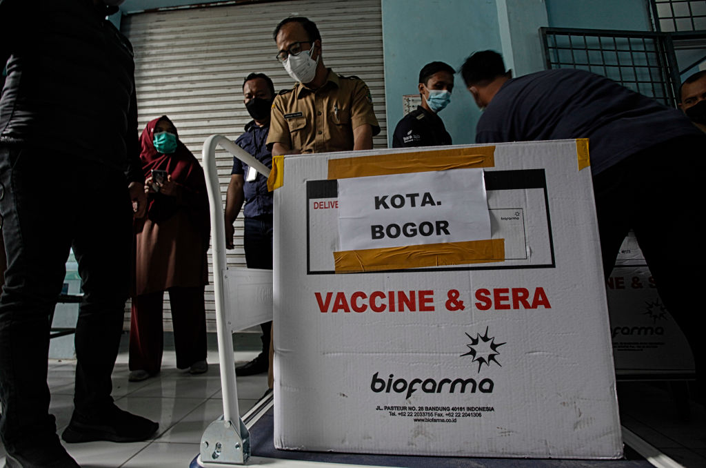 Workers carry transport boxes of the Sinovac Biotech COVID-19 vaccine in Bogor, West Java, Indonesia, on January 12, 2021. President Joko Widodo is set to get vaccinated against the coronavirus on Wednesday, Jan. 13. (Adriana Adie–NurPhoto/Getty Images)