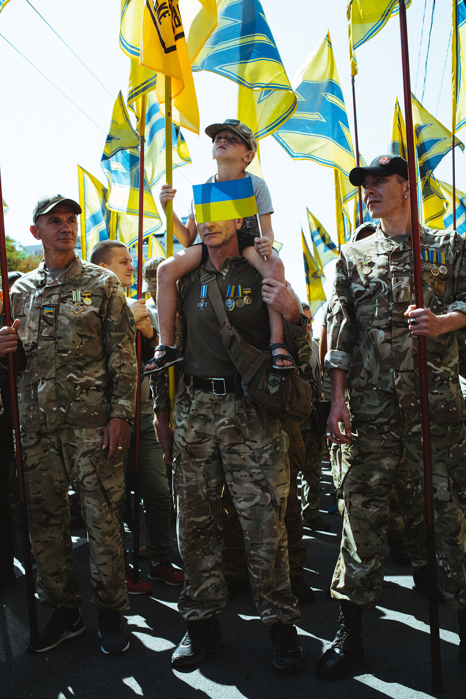 Azov Regiment veterans, whose banners carry an emblem derived from a Nazi symbol, the Wolfsangel, march in Kyiv in 2019.