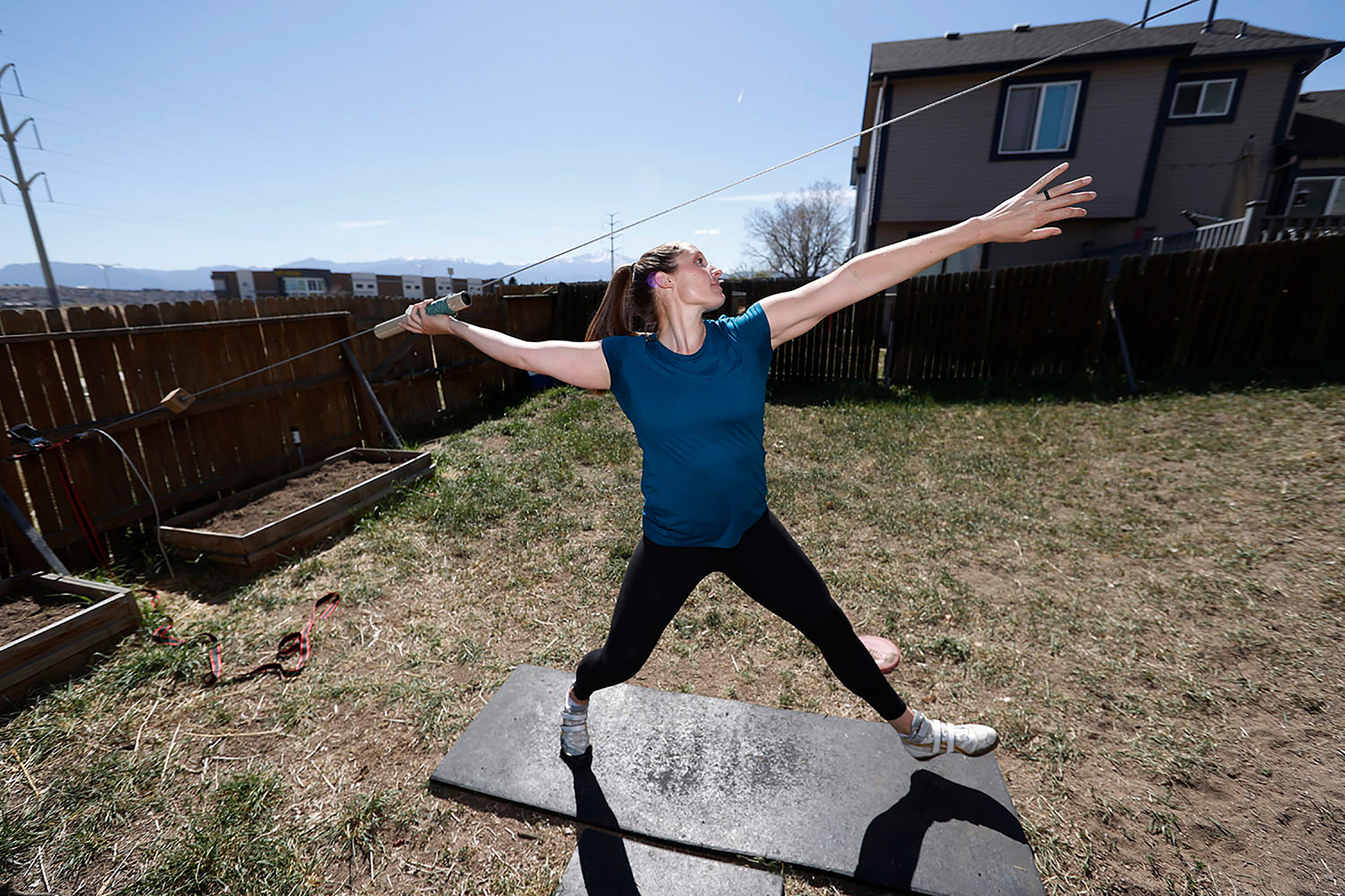 Winger uses a cable system to simulate throwing a javelin as she trains outside her home in Colorado Springs in April (David Zalubowski—AP)