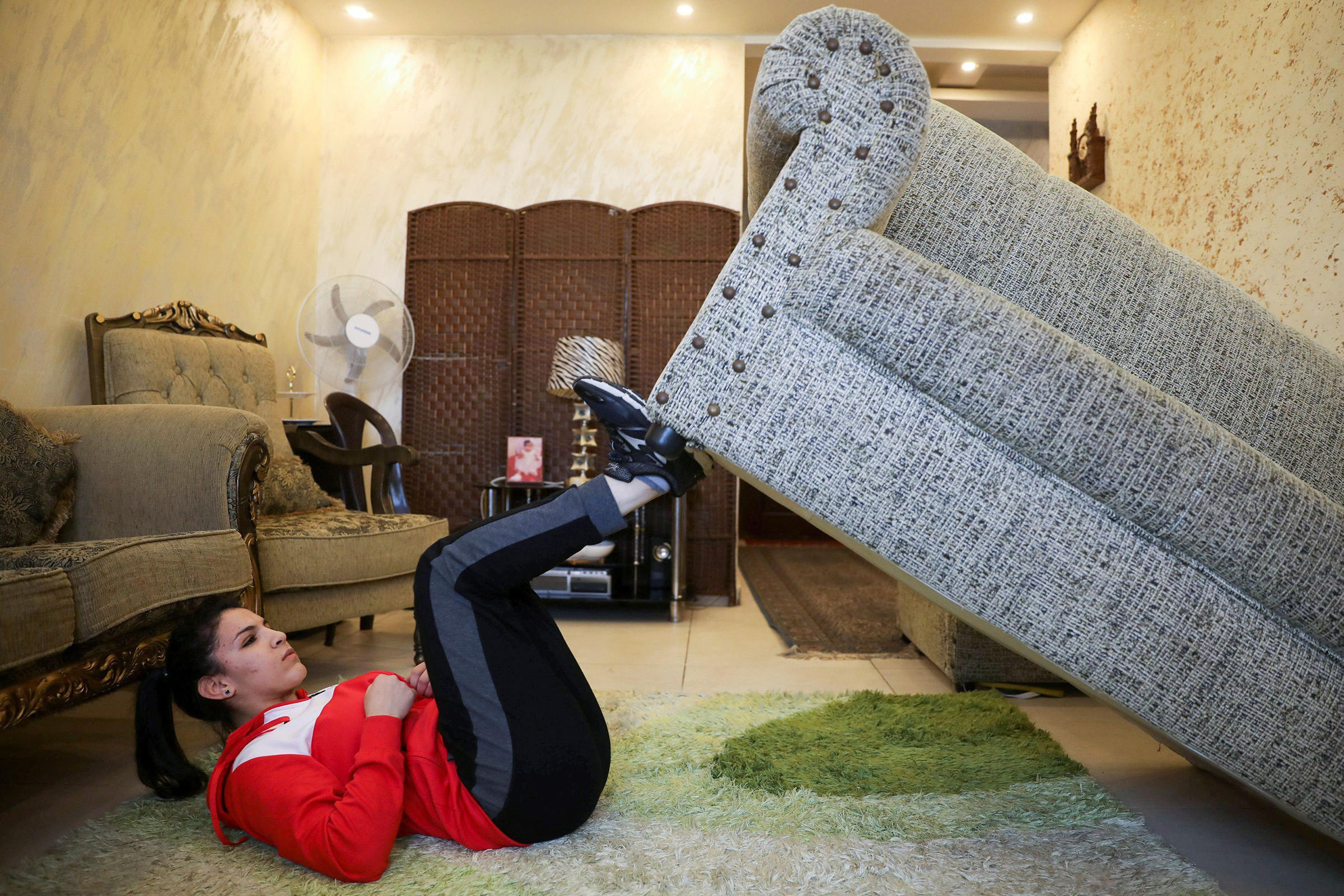 Jordanian judo practitioner Hadeel Alami uses the sofa as a part of her trainings at her home in Amman in April