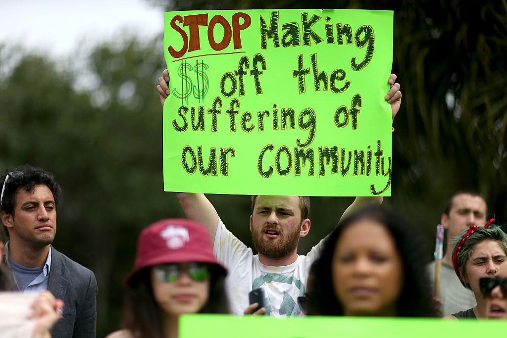 Protesters gather in front of the GEO Group headquarters to speak out against the company that manages private prisons across the United States on May 4, 2015 in Boca Raton, Florida. (Joe Raedle—Getty Images)