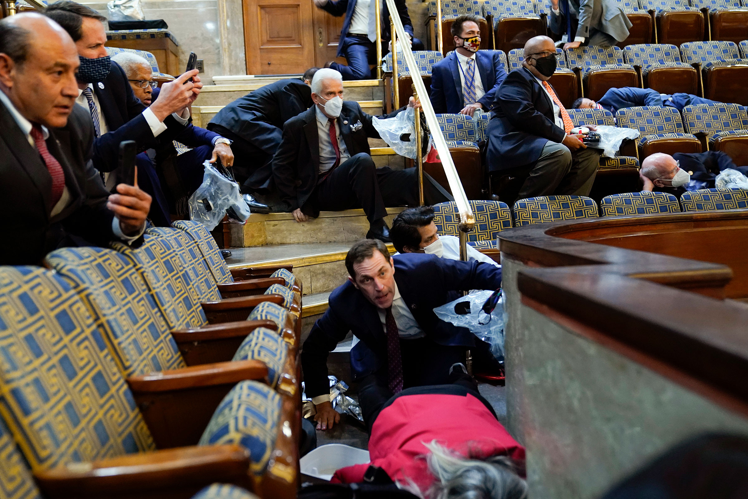 People shelter in the House gallery as protesters try to break into the House Chamber on Jan. 6, 2021.