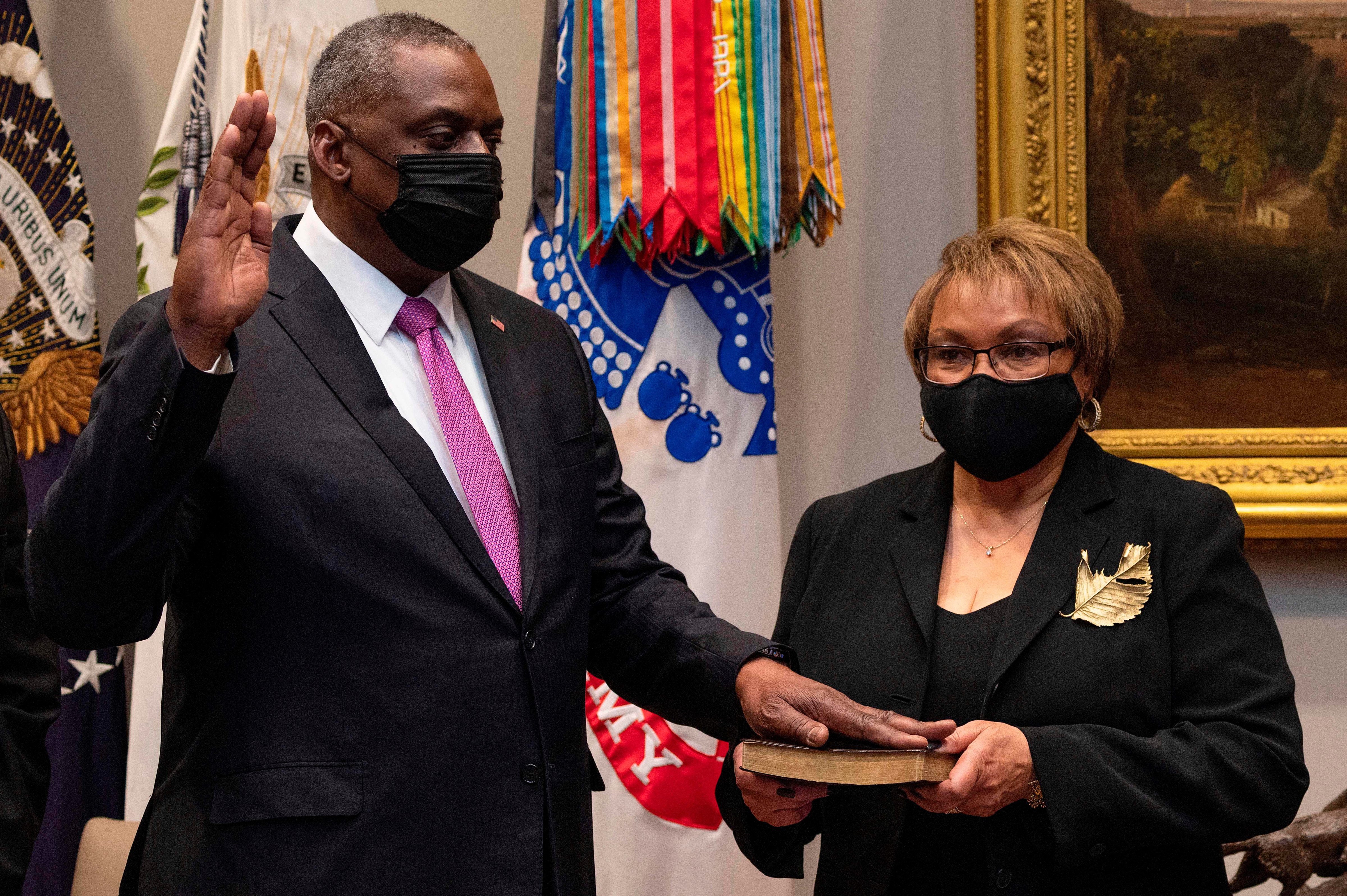 Lloyd Austin, a retired U.S. Army four-star general, is sworn in as Secretary of Defense as his wife, Charlene Austin, holds the Bible in Washington D.C. on Jan. 25, 2021. (Jim Watson—AFP/Getty Images)