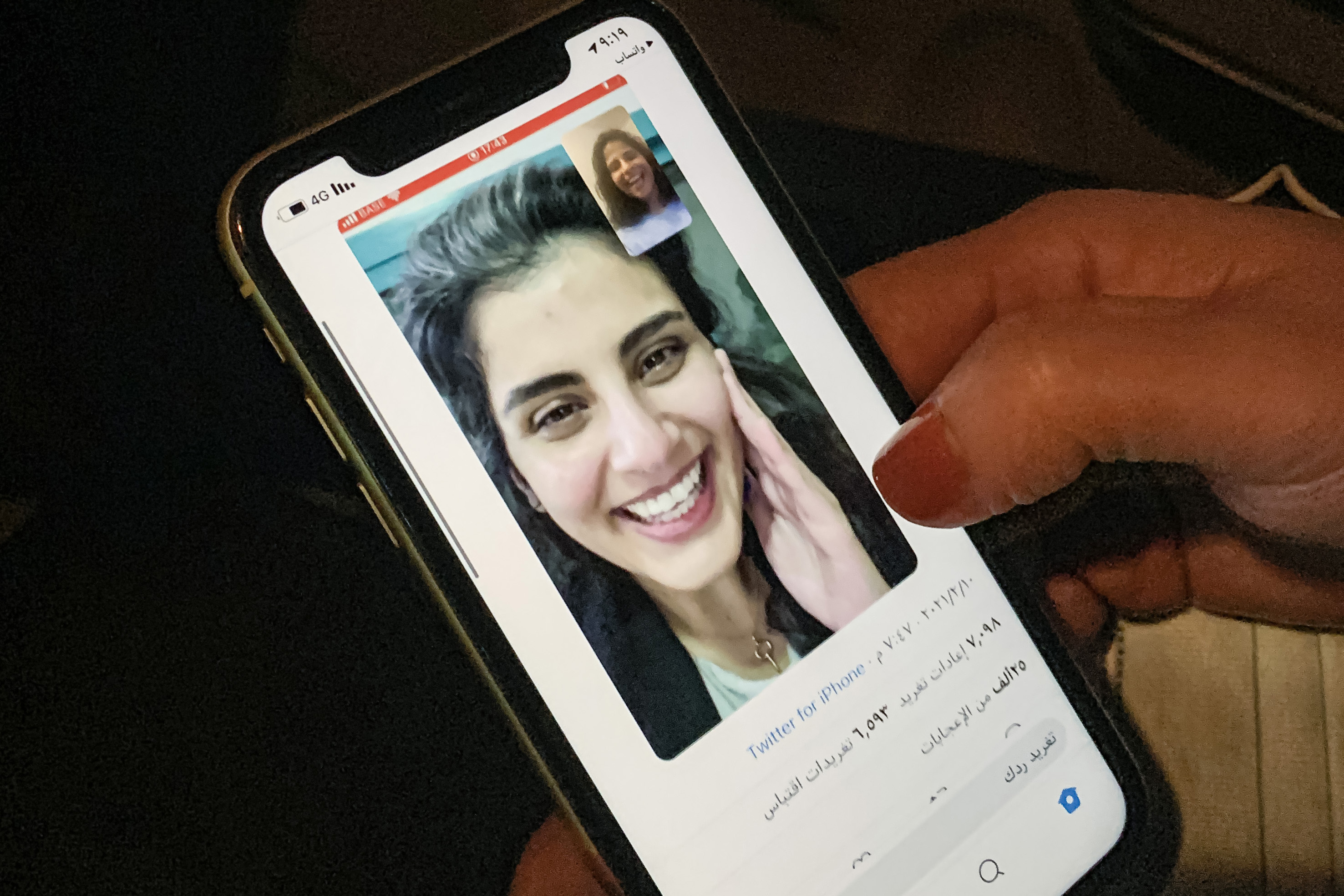 This picture taken February 10, 2021 in Saudi Arabia's capital Riyadh shows a woman viewing a tweet posted by the sister of Saudi activist Loujain al-Hathloul, Lina, showing a screenshot of them having a video call following Hathloul's release after nearly three years in detention. (Fayez Nureldine—AFP/Getty Images)