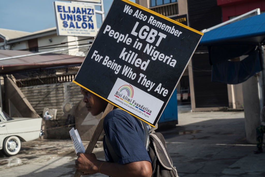 A young man holds a sign questioning LGBT killings during a march commemorating all the lives lost to violent killings in Lagos on May 28, 2018. (Stefan Heunis—AFP/Getty Images)