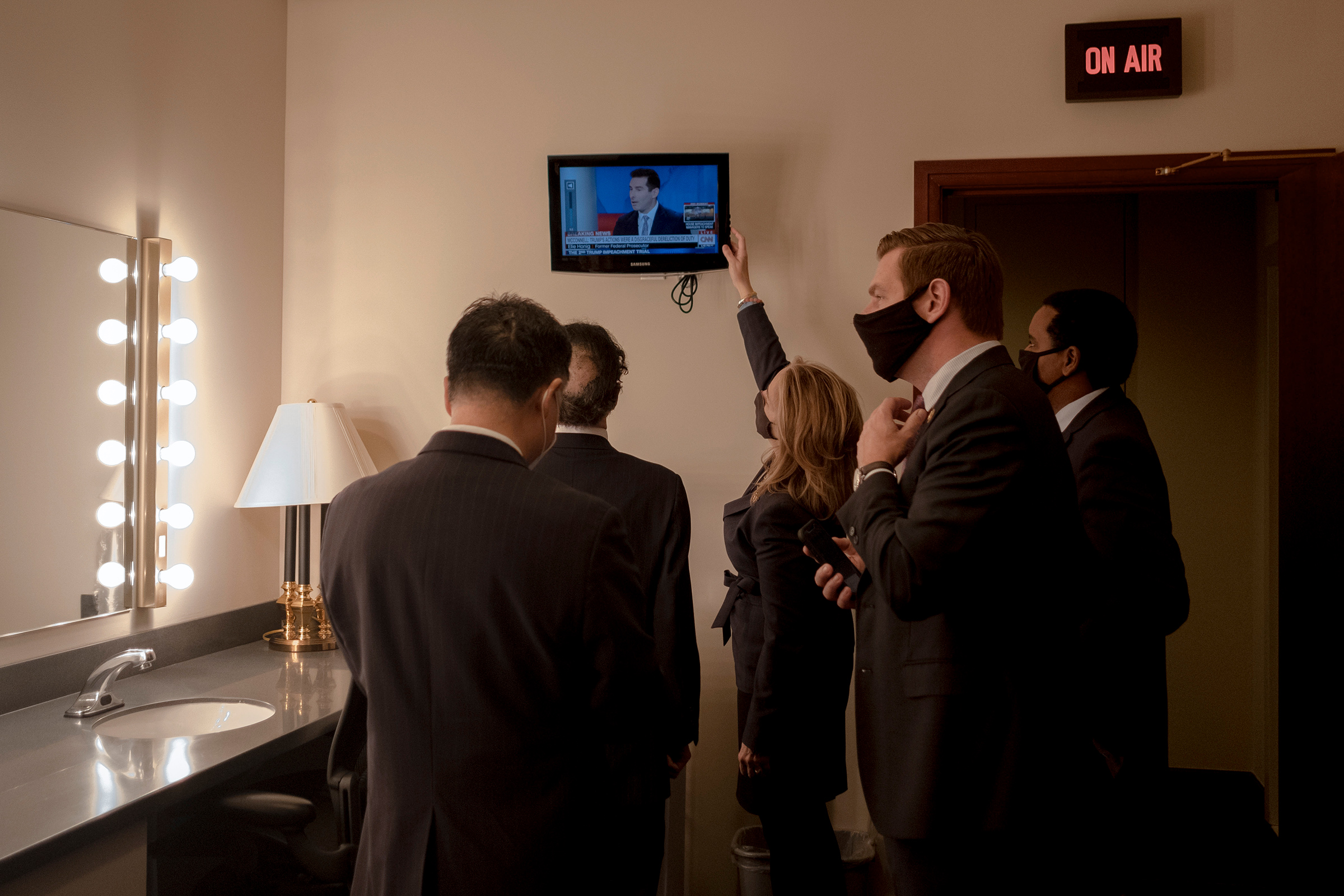 House managers watch the news as they prepare to speak to the press on Feb. 13, 2021. (Gabriella Demczuk for TIME)