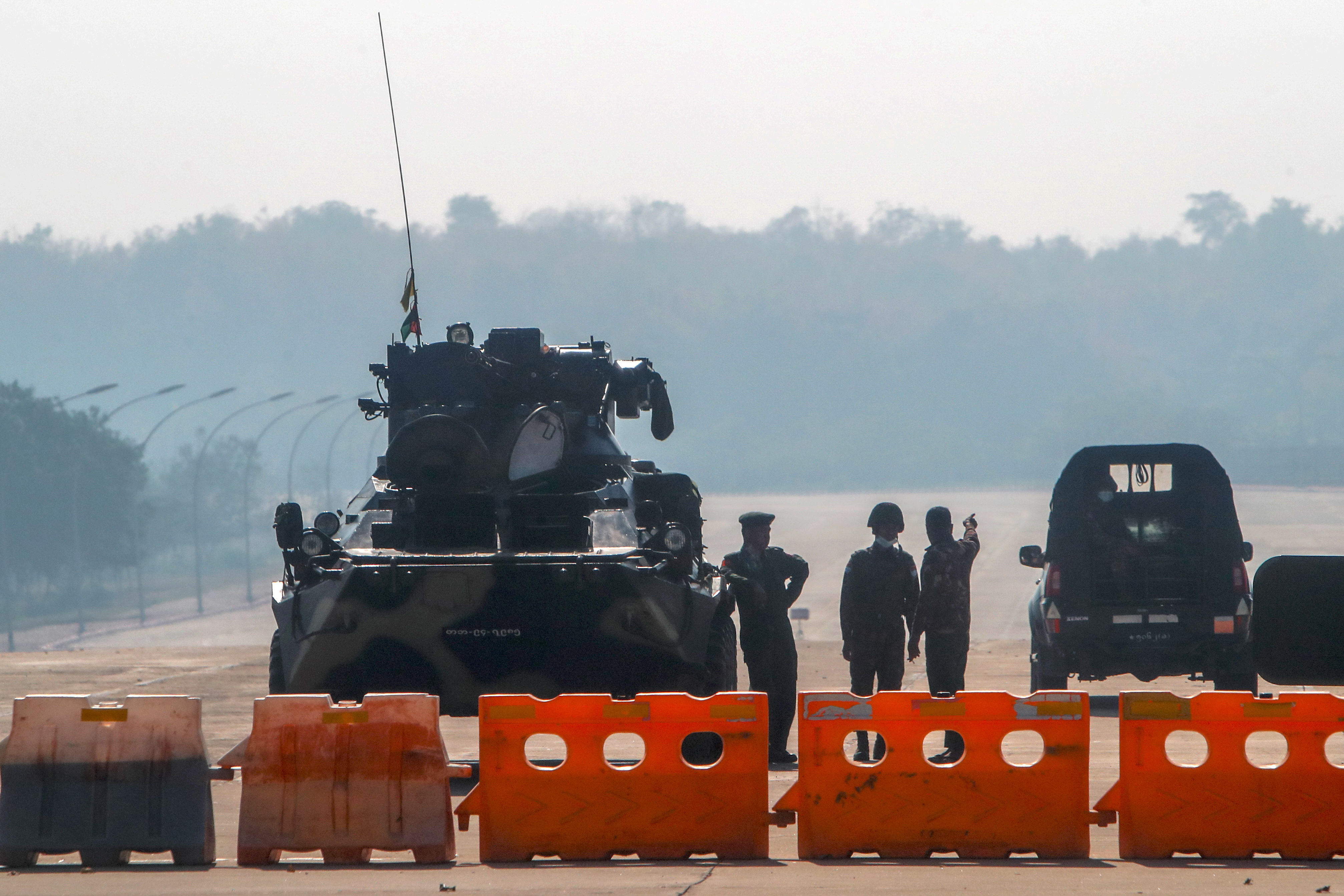 Myanmar's military stand guard at a checkpoint manned with an armored vehicle in a road leading to the parliament building Tuesday, Feb. 2, 2021, in Naypyitaw, Myanmar. (AP)