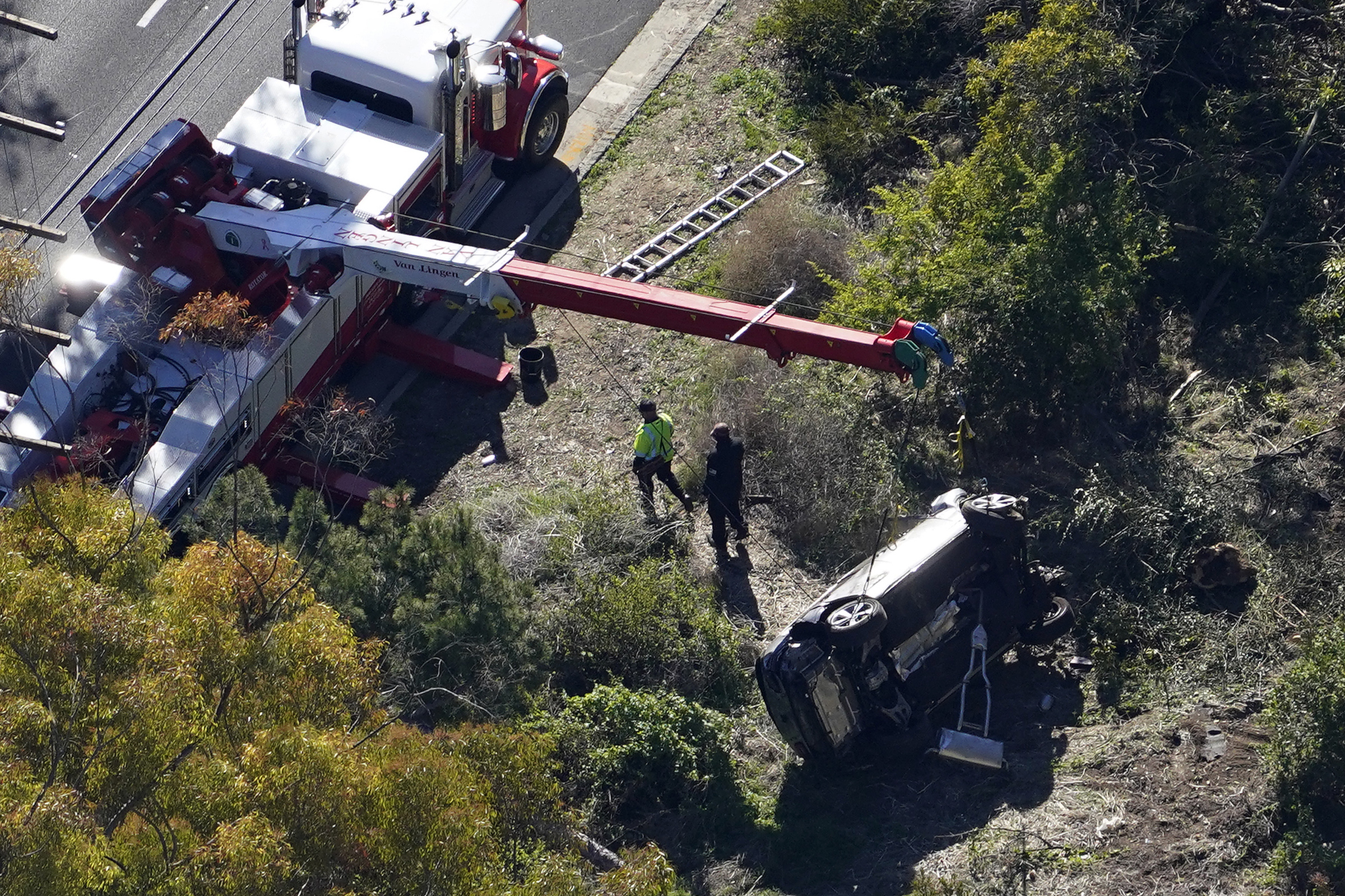 A crane is used to lift a vehicle following a rollover accident involving golfer Tiger Woods in Rancho Palos Verdes, Calif., on Feb. 23, 2021. (Mark J. Terrill—AP)