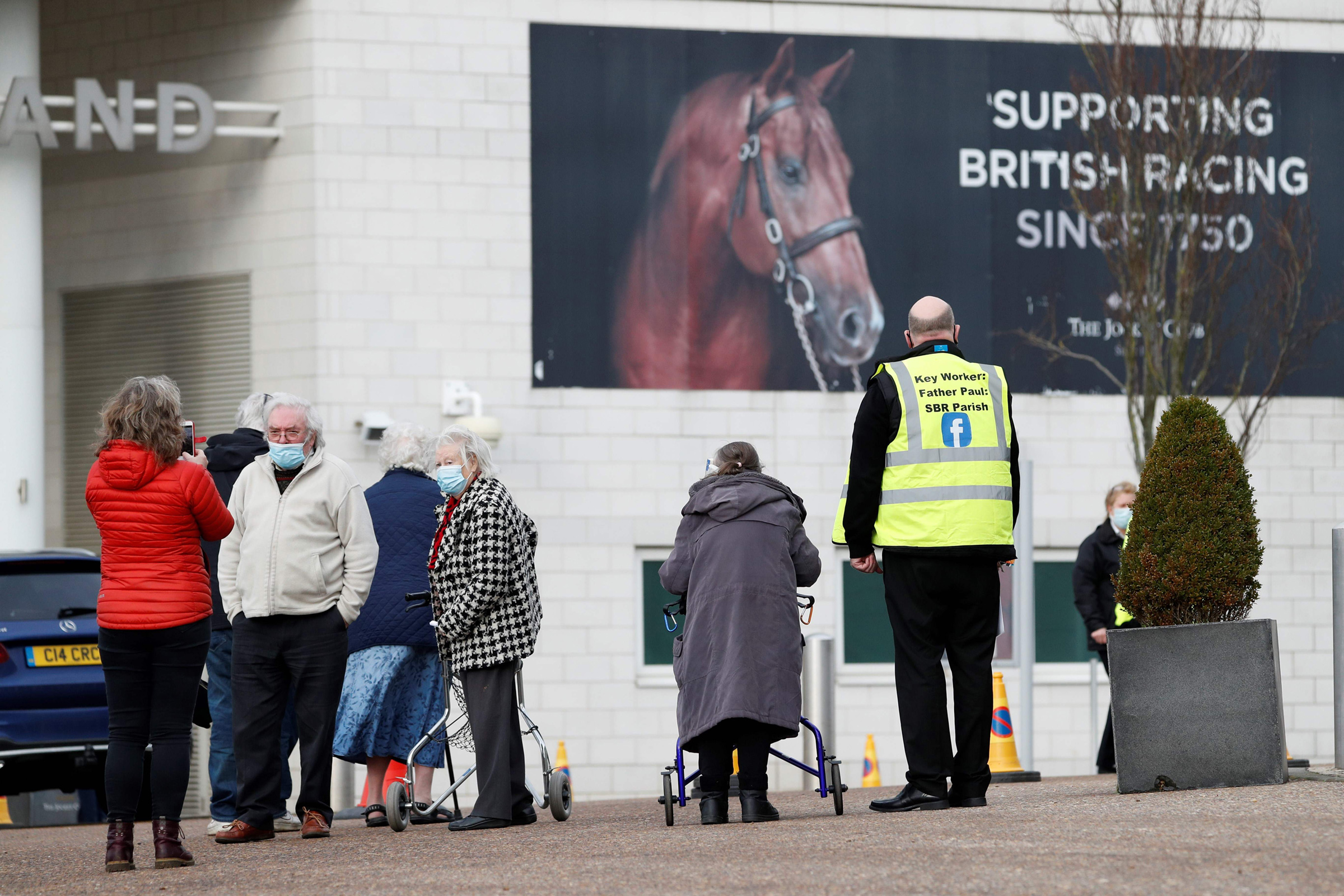 People arrive at Epsom Downs Racecourse as it opens as a COVID-19 vaccination center in Epsom, England, on Jan. 11, 2021. (Adrian Dennis—AFP/Getty Images)