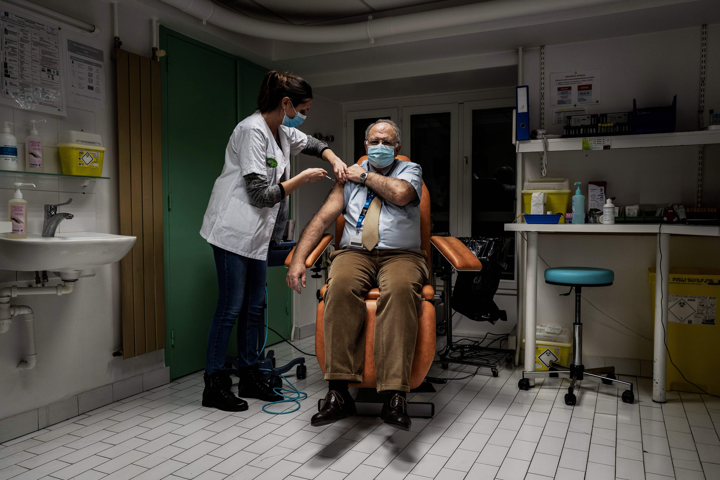 A nurse injects a dose of the Pfizer-BioNTech Covid-19 vaccine to a member of the medical staff at the Croix Rousse Hospital in Lyon, France, on Jan. 6, 2021. (Jeff Pachoud—AFP/Getty Images)