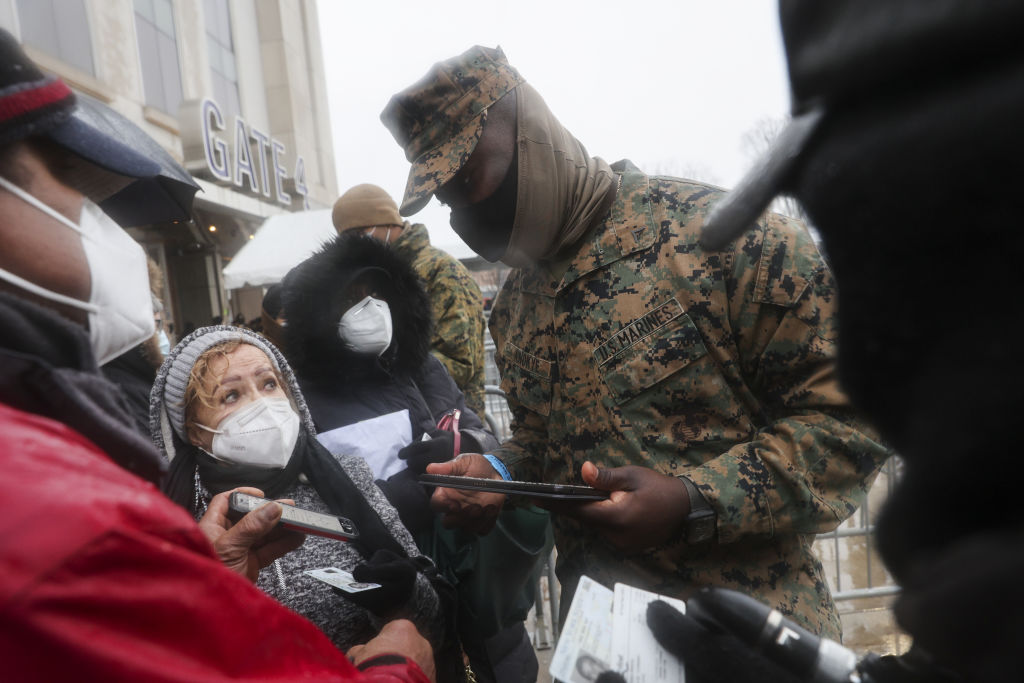 A member of the U.S. Marines registers people wearing protective masks outside a COVID-19 vaccination hub inside Yankee Stadium in the Bronx borough of New York, U.S., on Feb. 5, 2021. (Angus Mordant—Bloomberg/Getty Images)