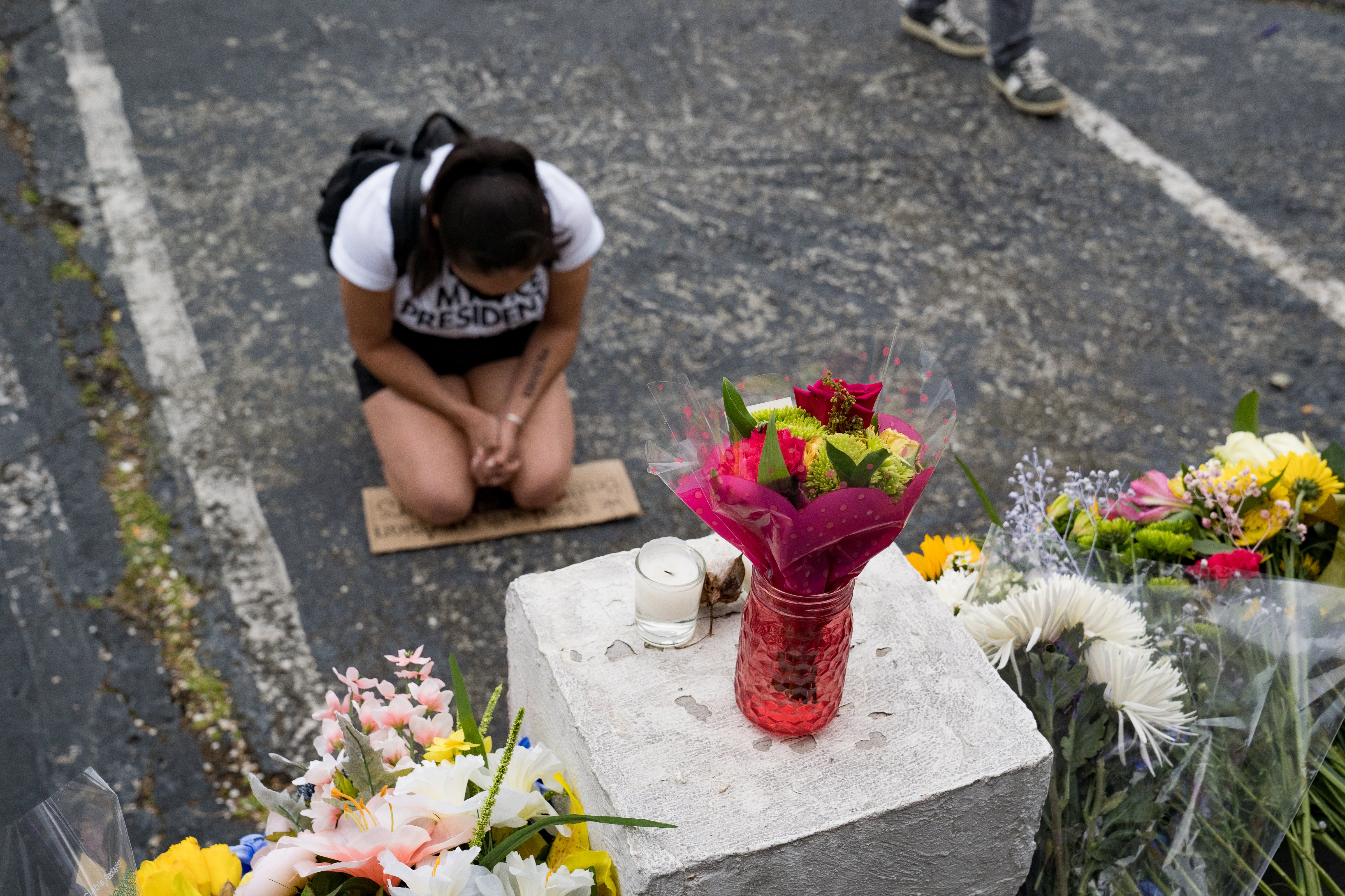 A woman kneels at a memorial outside the Gold Spa in Atlanta on March 18, one of three spas attacked by a gunman who killed eight the previous day (Megan Varner—Getty Images)